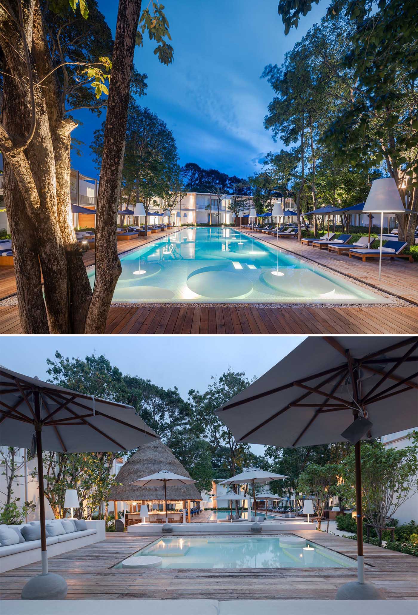 A resort swimming pool with oversized lights and a wood deck.