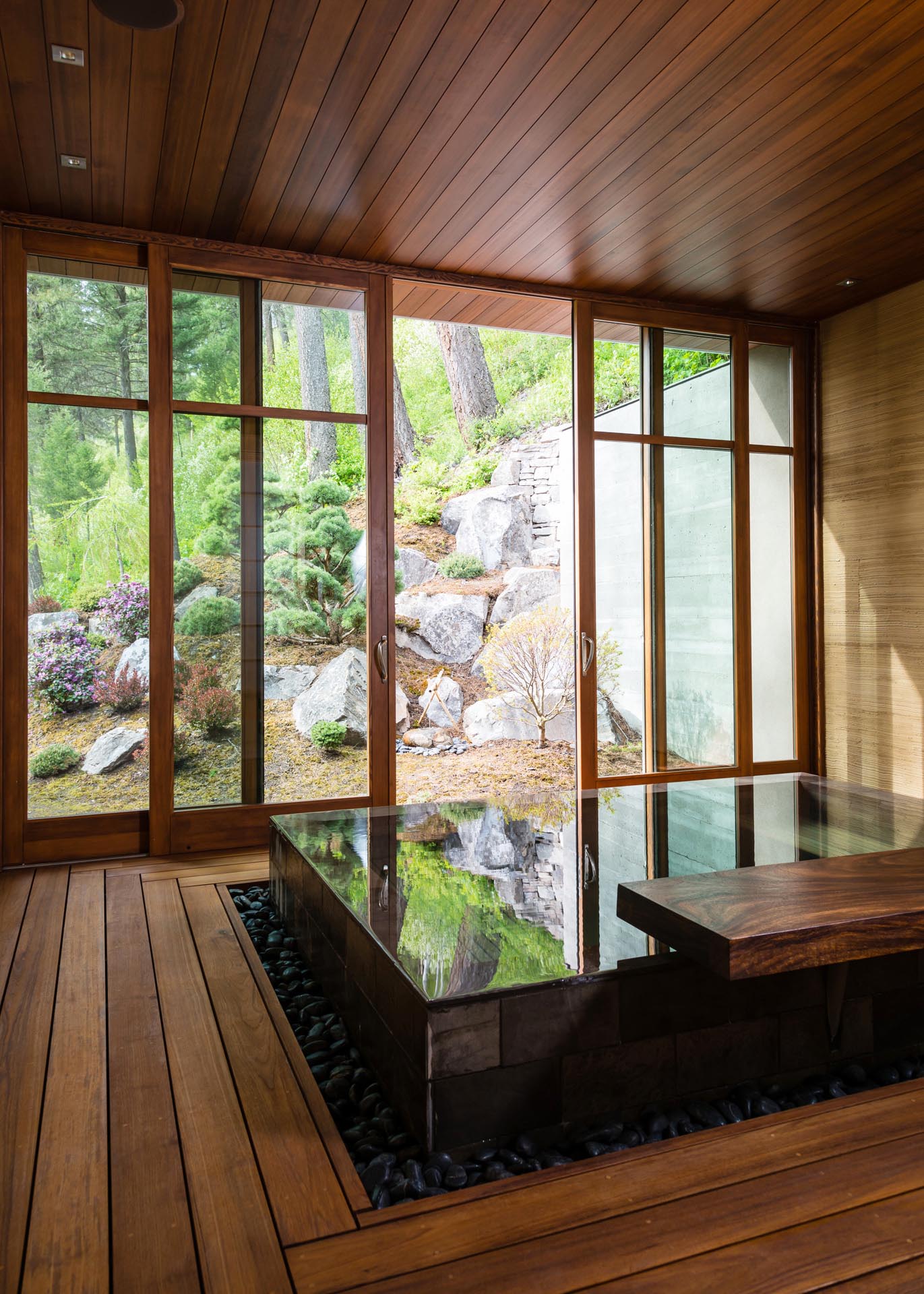 The stand-alone bathhouse features an infinity edge, custom-designed limestone soaking tub and sliding doors that open to the outdoors.