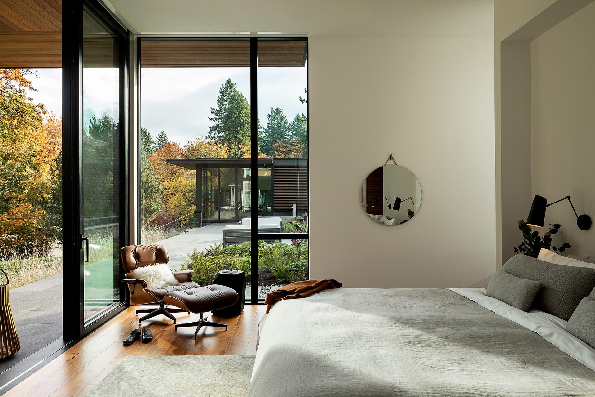 A modern bedroom with large windows and a door that opens to a terrace.