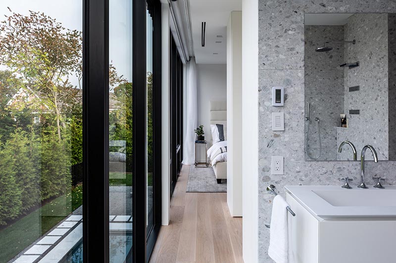 Black-framed windows contrast the light interior of the primary bedroom and en-suite bathroom.