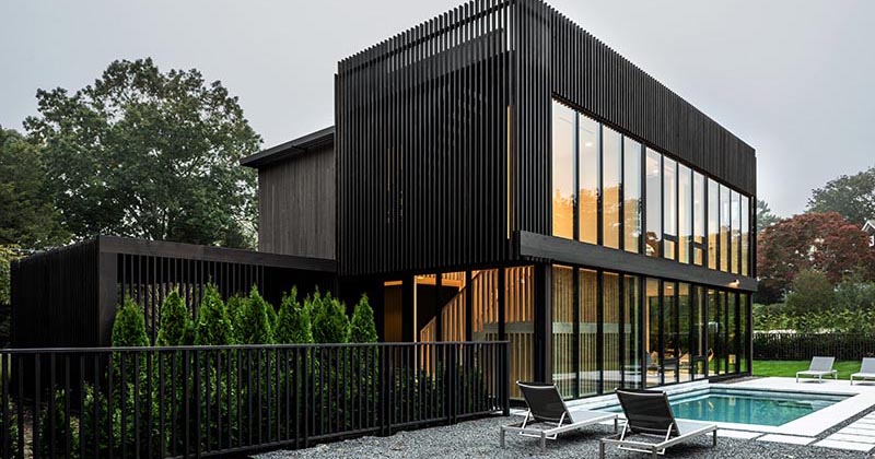 An Exterior Of Vertical Black Wood Siding Creates A Strong Look For This House