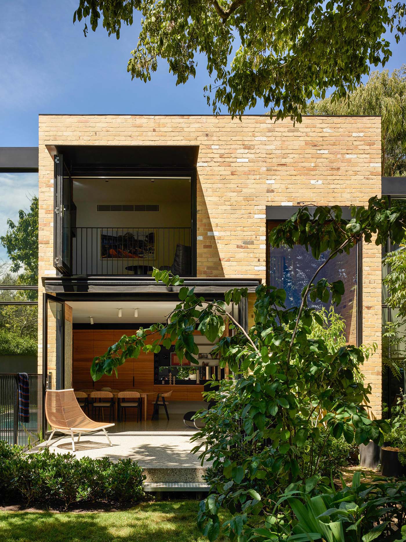 A modern home with indoor/outdoor living spaces, has been built using recycled yellow brick.