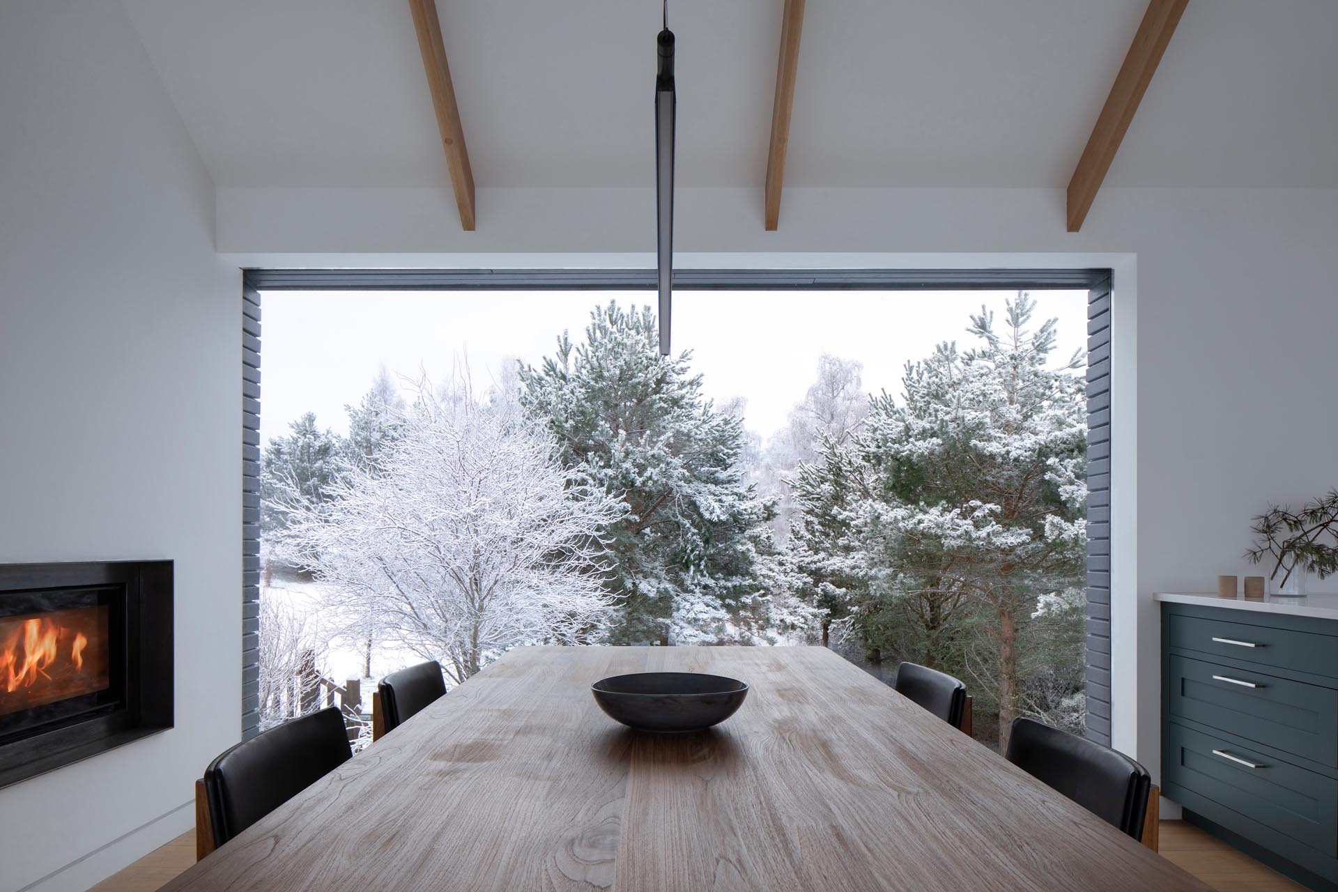 A modern dining room that enjoys a picturesque view of the trees.