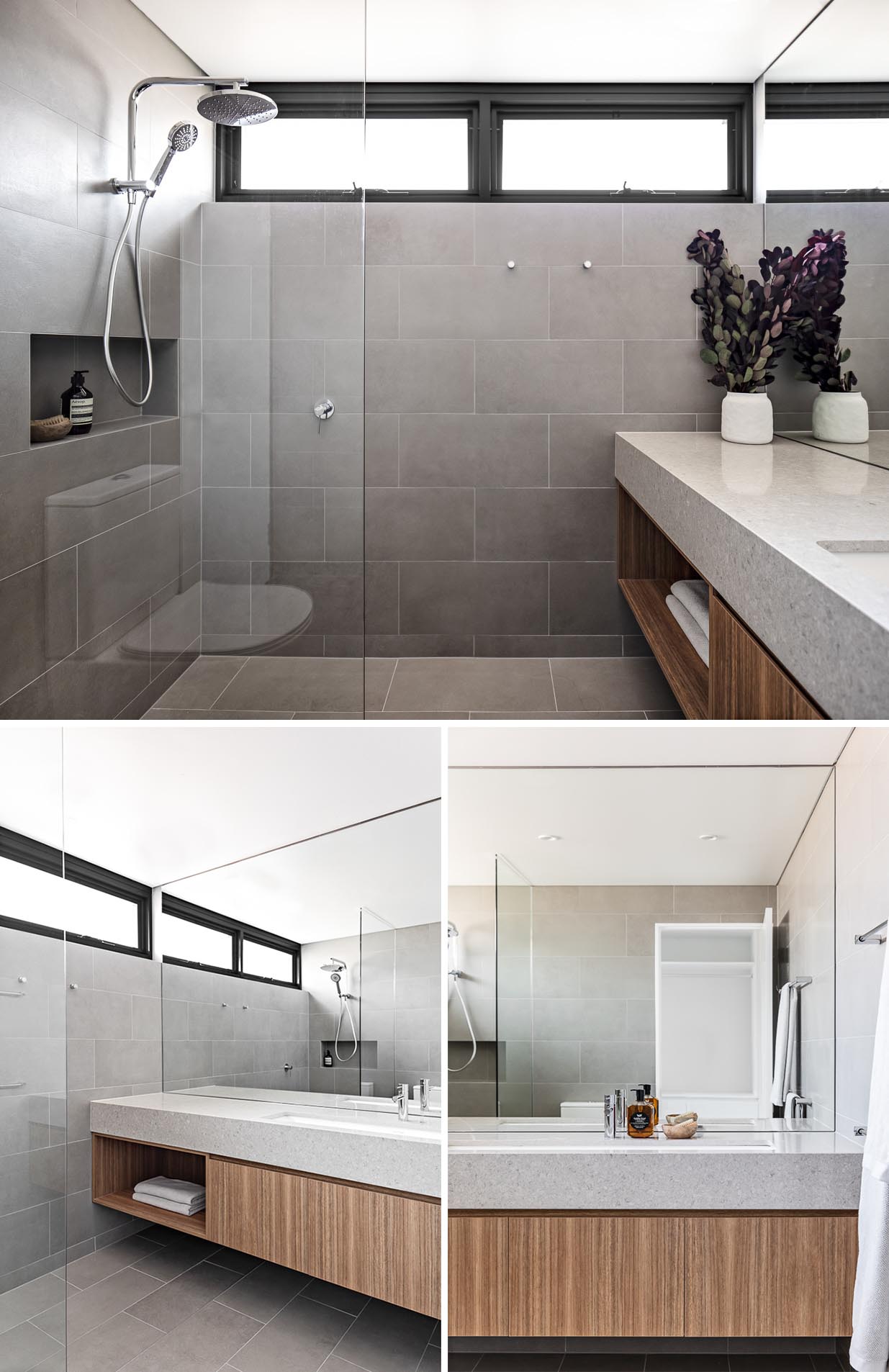 A modern bathroom with large gray tiles that cover the walls and floor, a floating wood vanity, and a shower niche. 