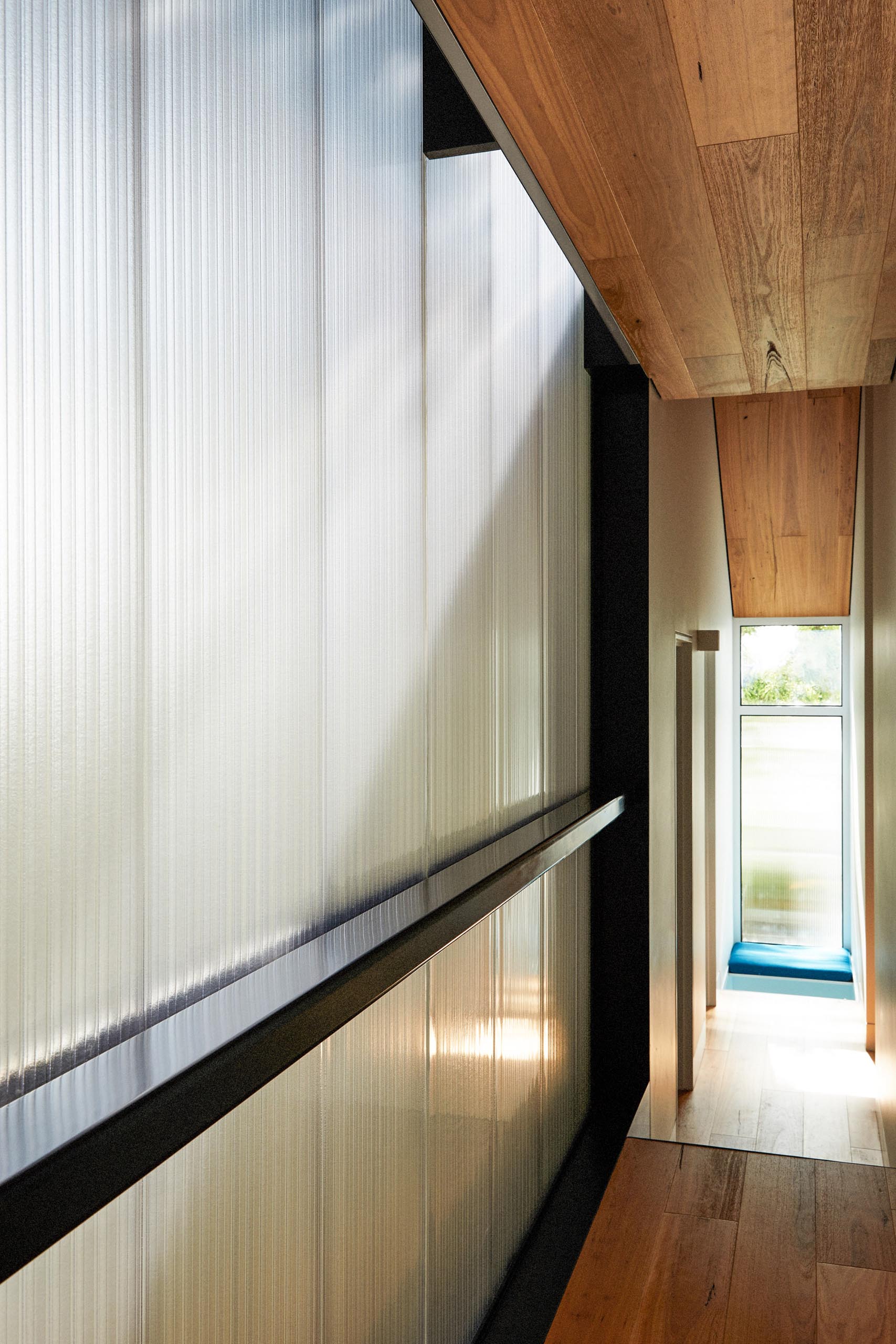 At the end of this hallway is a small seating niche by the window that includes upholstered benches, ideal for when the children want to have a quiet moment.