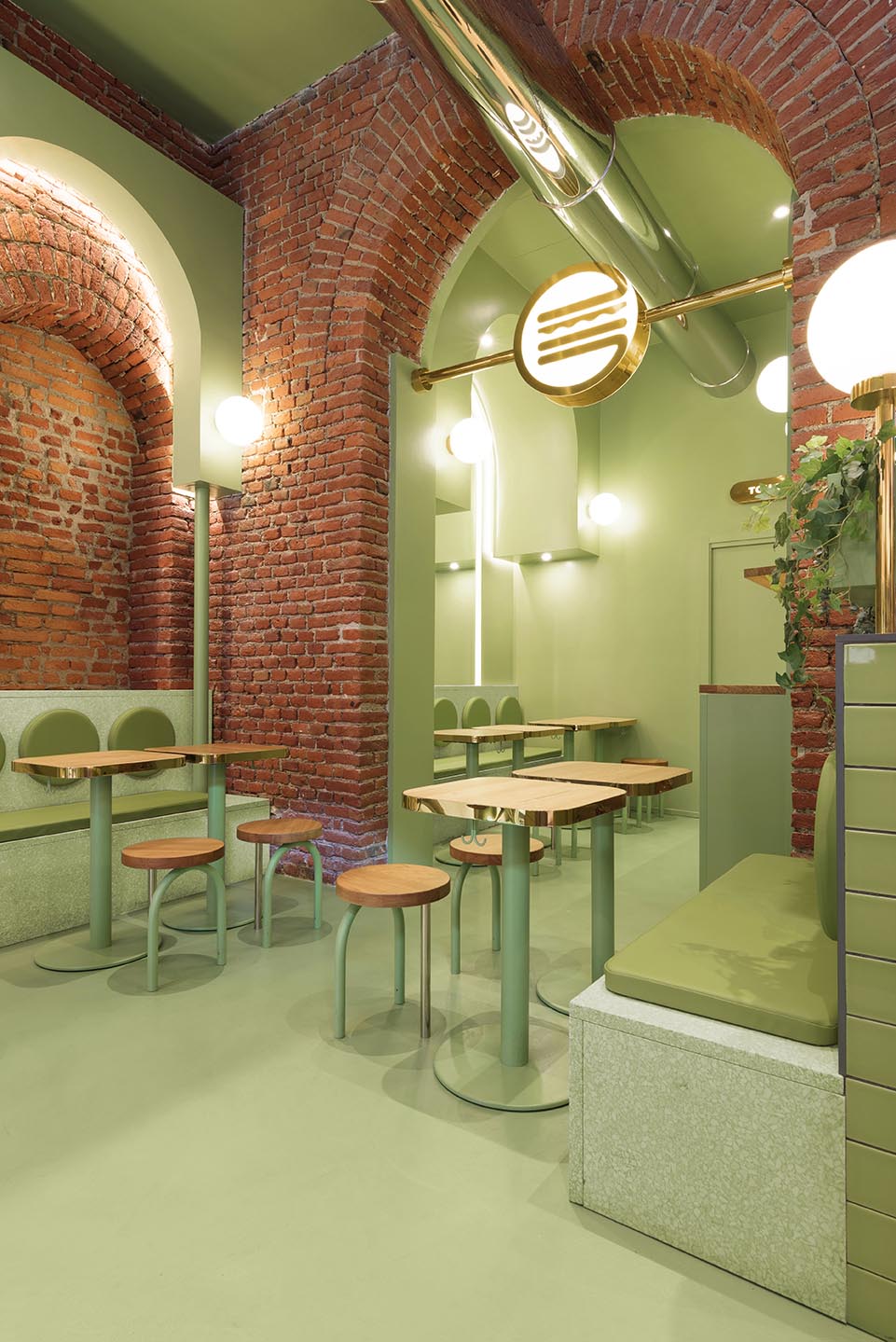 A new restaurant in Milan, Italy, uses a colorful green and brick interior to draw people inside.