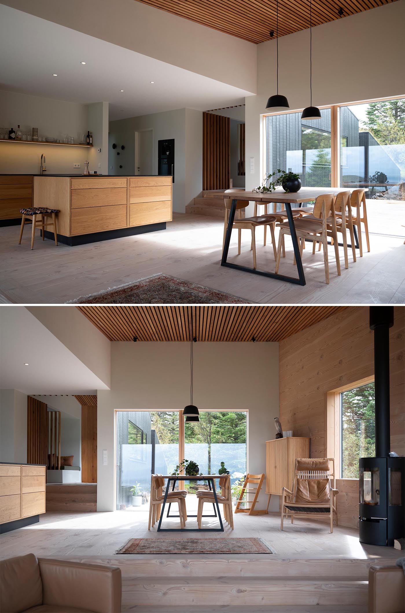 Inside this modern home, there's an open plan kitchen and dining room. Both have black accents, however the dining room also includes a wood slat ceiling and a black fireplace.