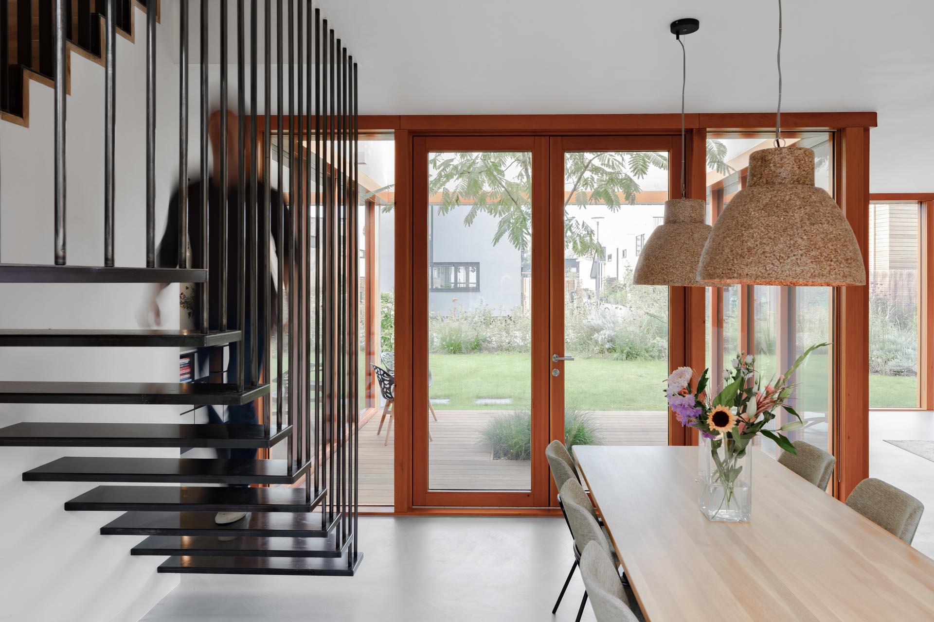 Modern black stairs that contrast the wood and glass in the dining room.