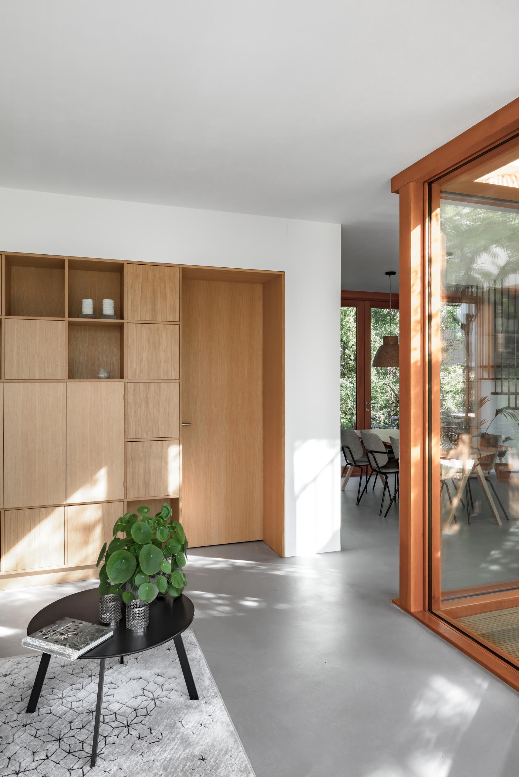 Inside this modern home, bright white walls contrast the wood shelving and interior doors, and the gray flooring.