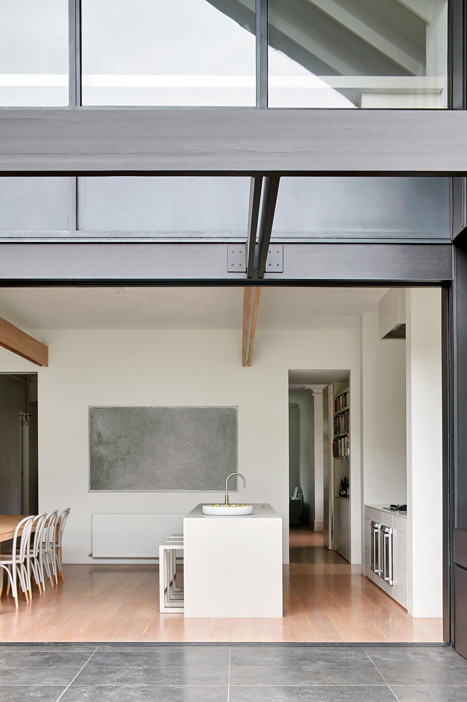 A minimalist kitchen with an island and tiled wall.