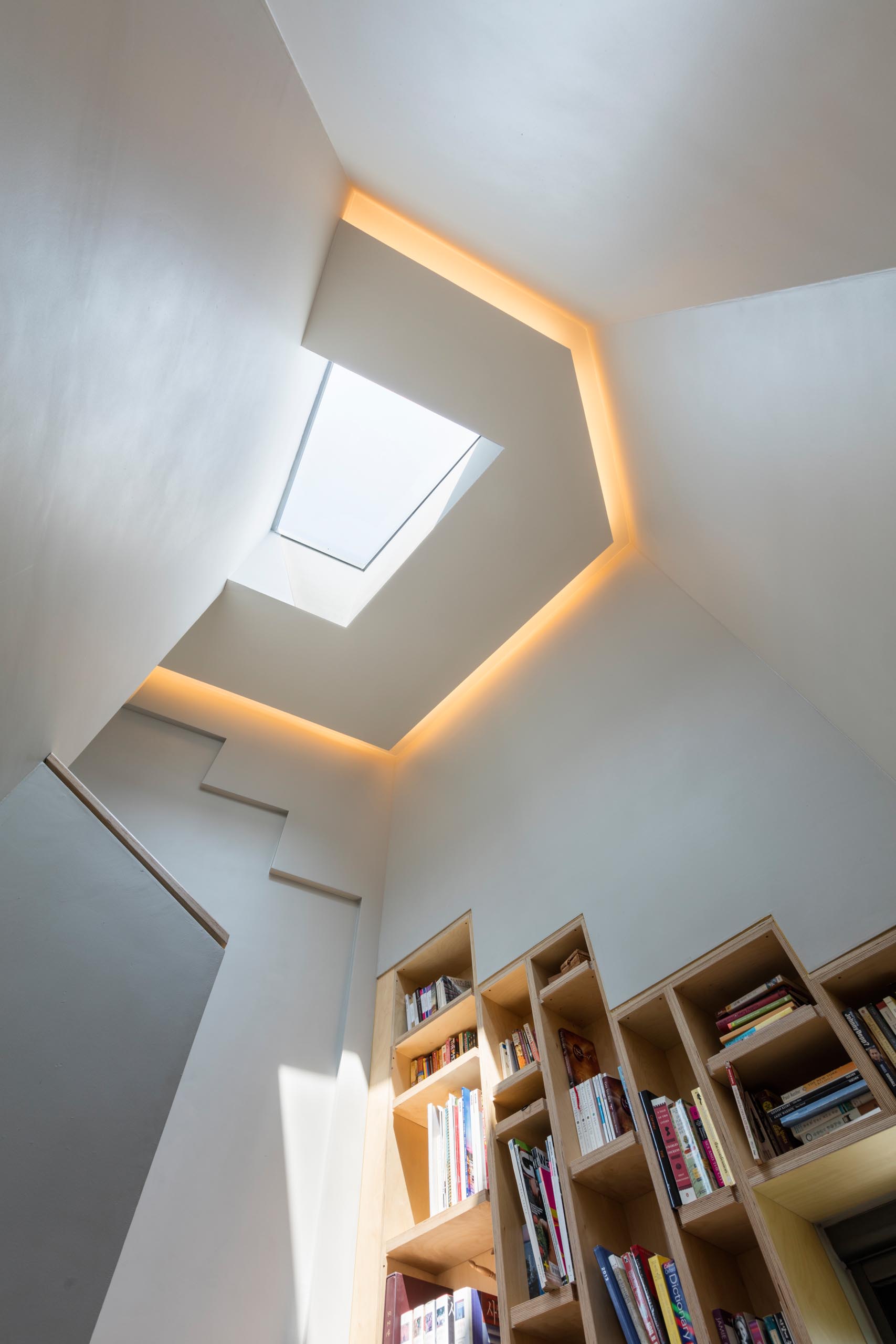 A modern home with a skylight, hidden lighting, and built-in bookshelves.