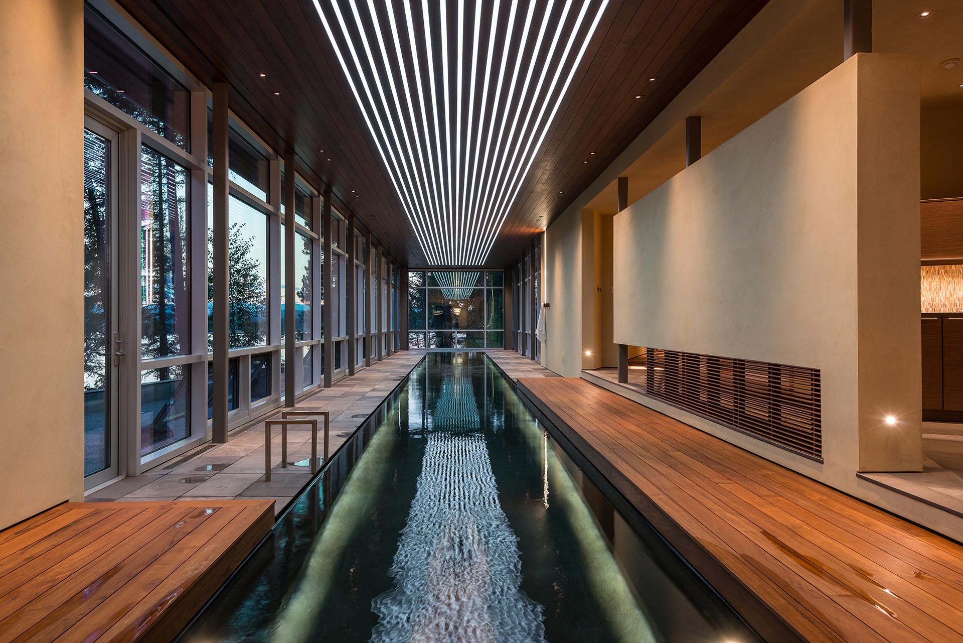 An indoor swimming pool with lighting integrated into the ceiling.