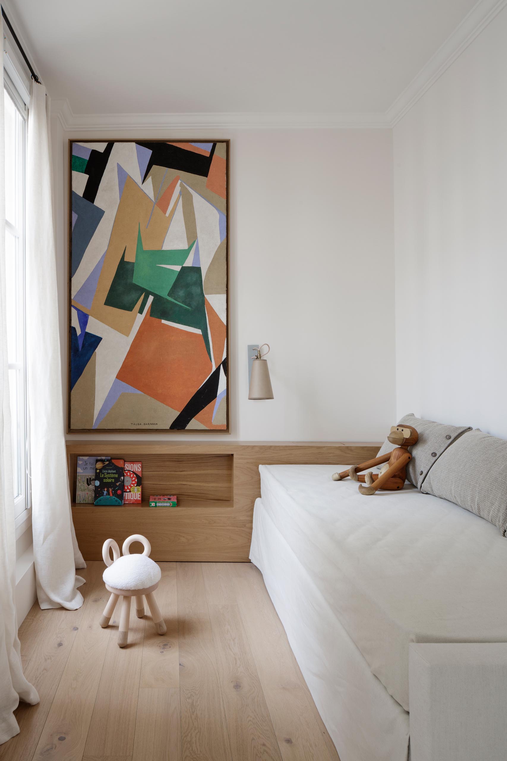 In this modern kids bedroom, calm colors have been paired with textures and artwork to create relaxed and cozy space.