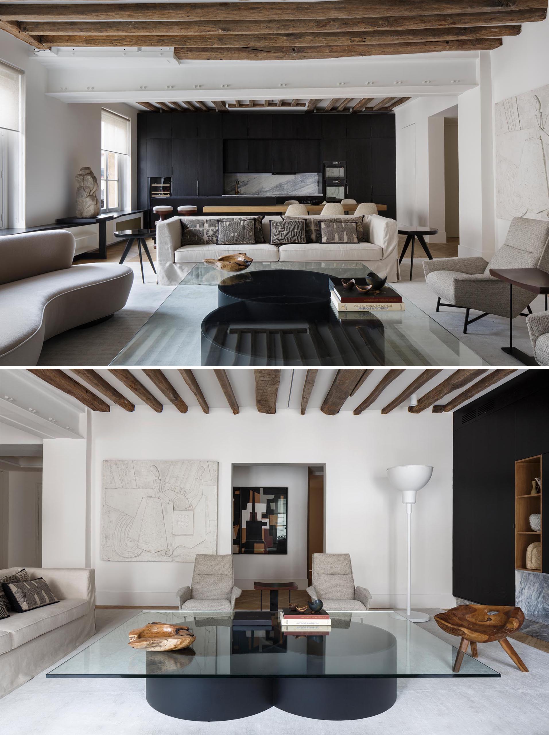 A modern matte black kitchen contrasts the neutral colored living room.