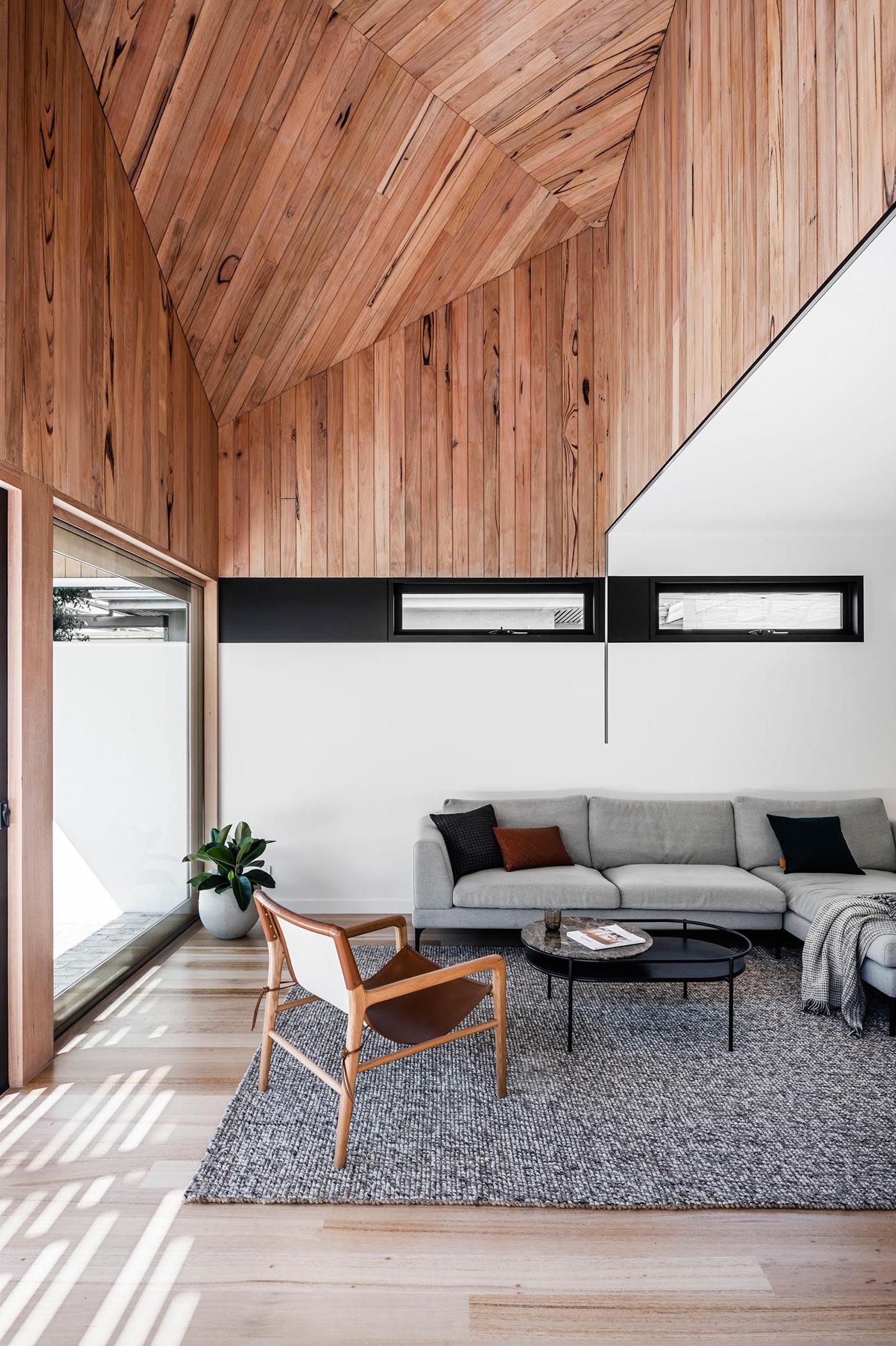 A modern living room with a wood ceiling.