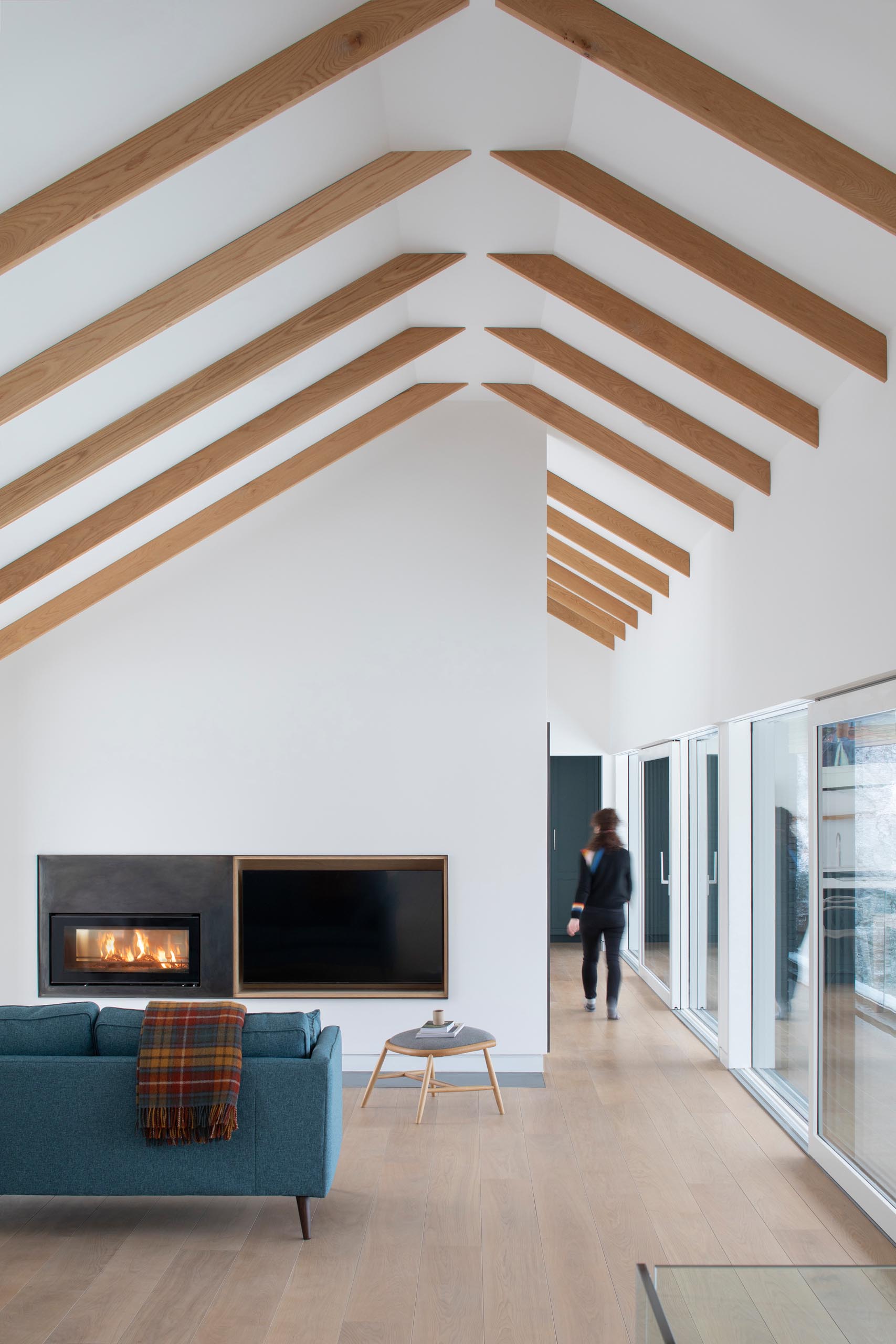 A modern living room with a steel fireplace surround and a wood-lined niche for a television.