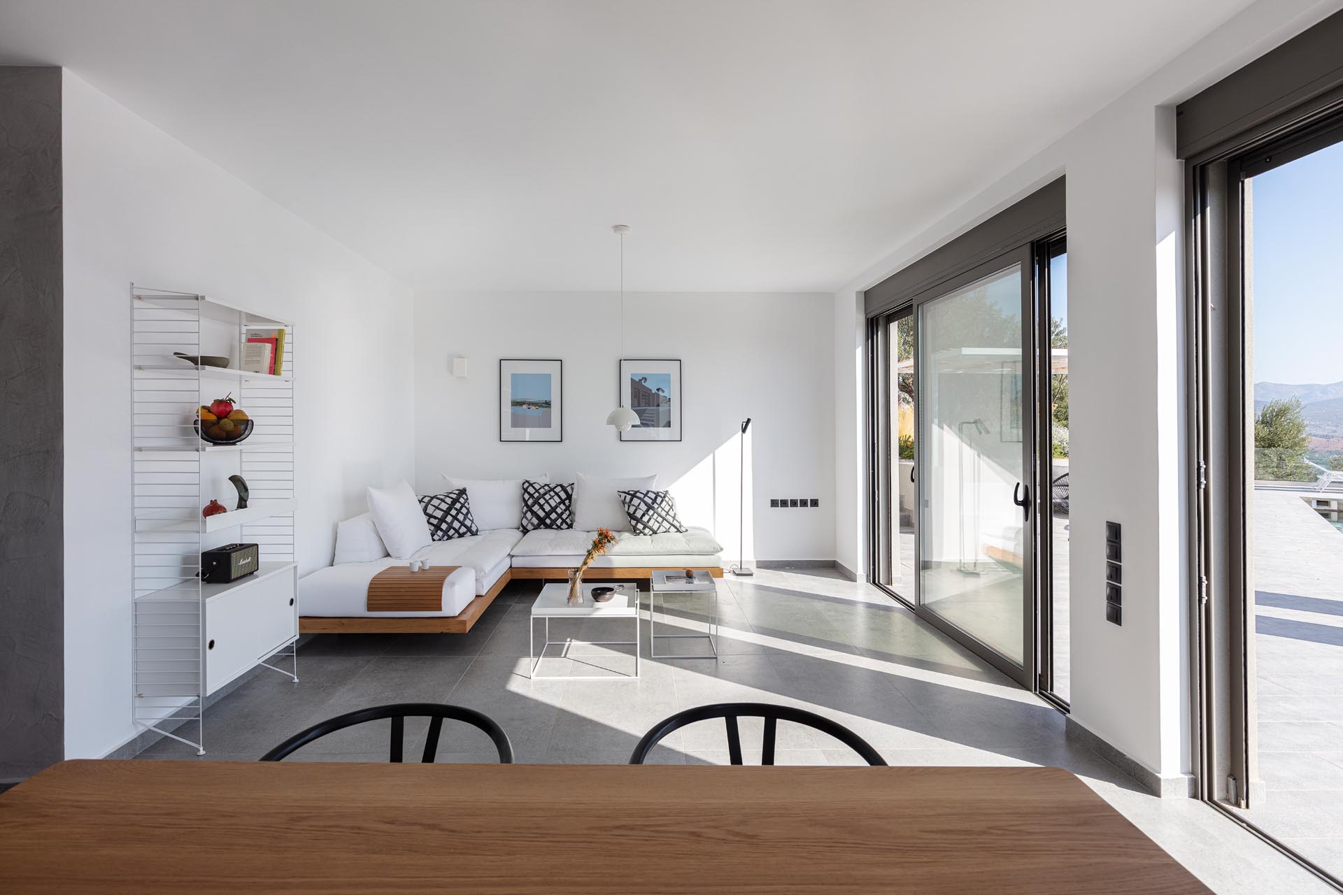 A modern white living room with concrete floors and wood accents.