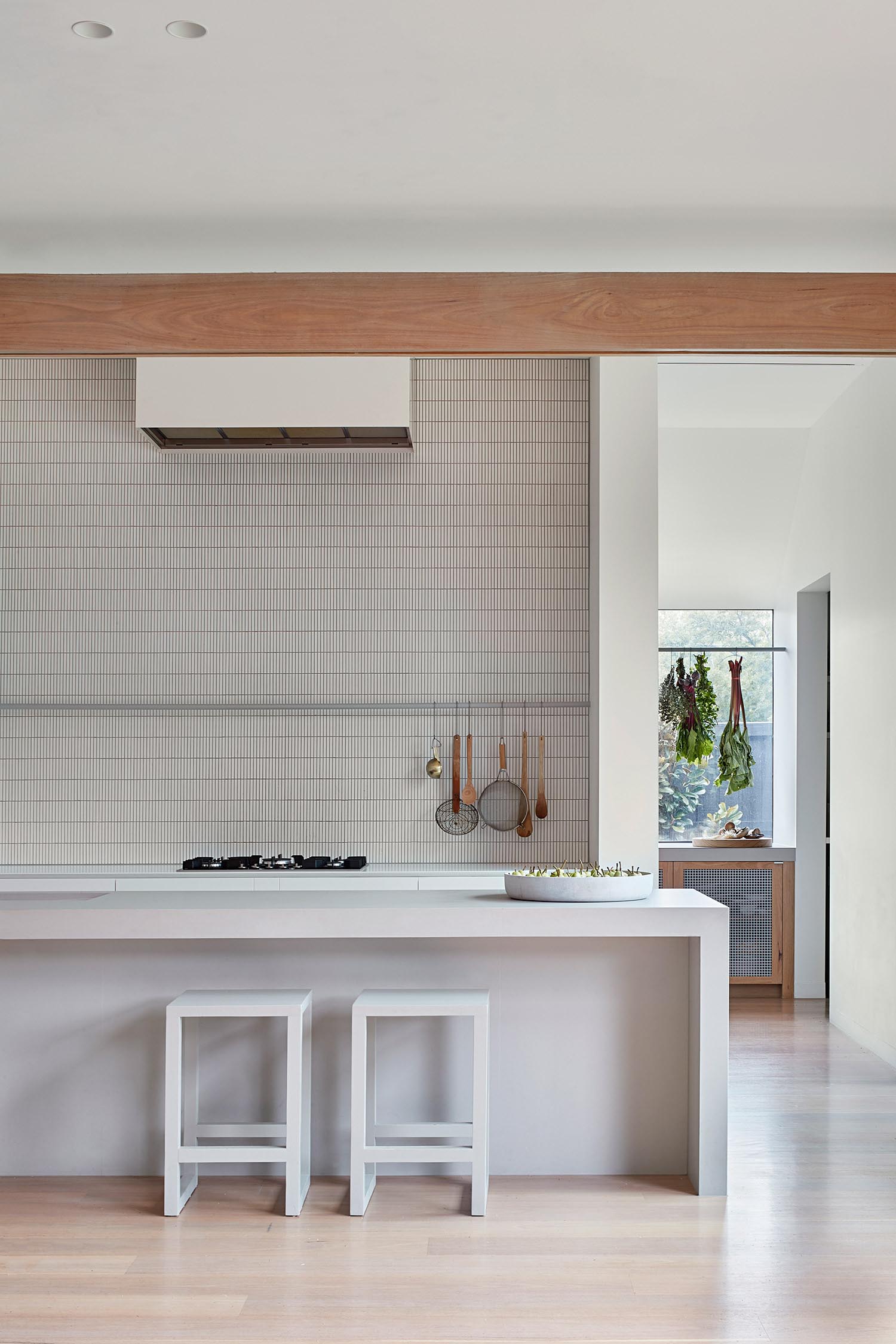 A minimalist kitchen with an island and tiled wall.