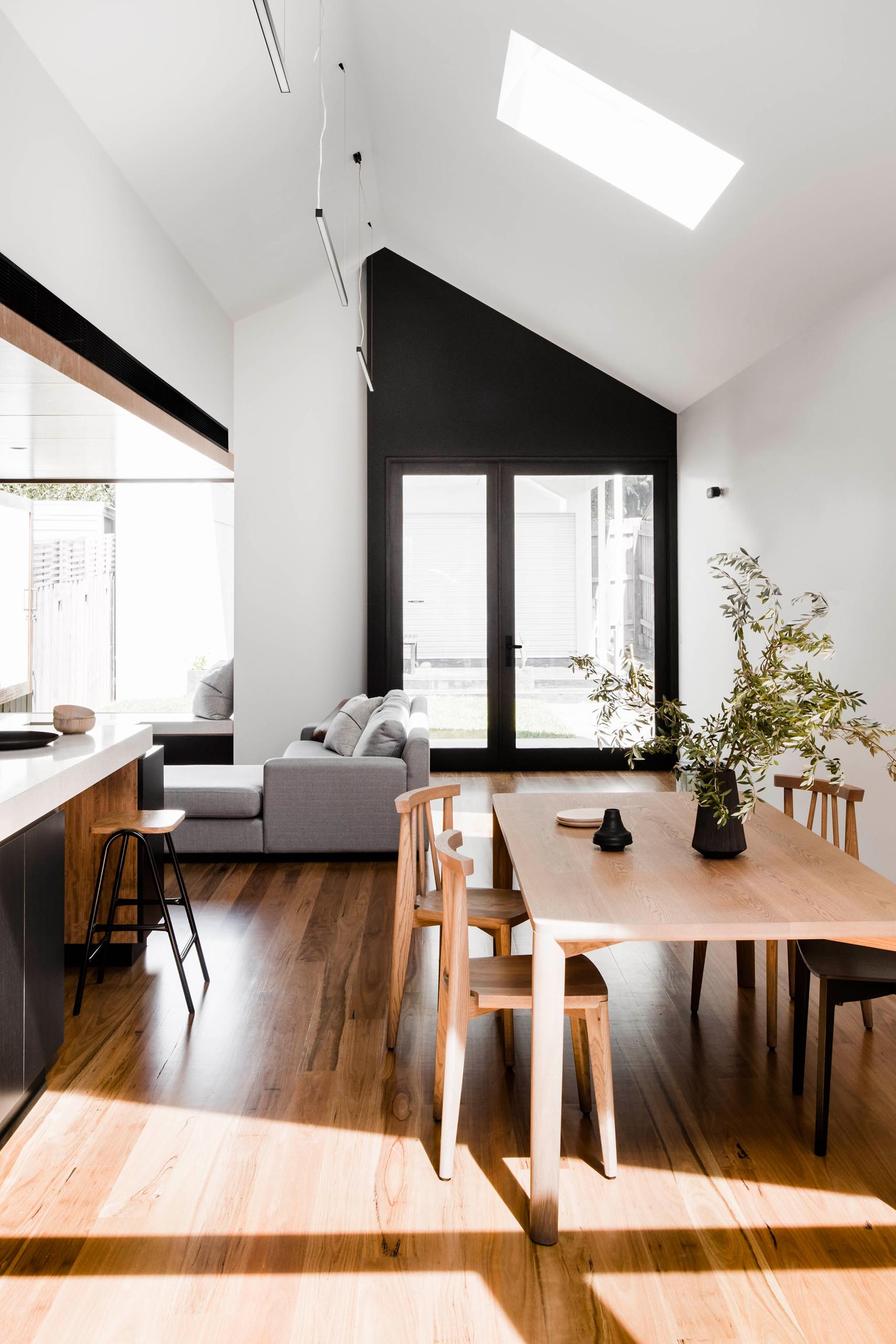 Black accents continue throughout this modern home in the form of lighting, furniture, decorative items, accent walls, and door frames.