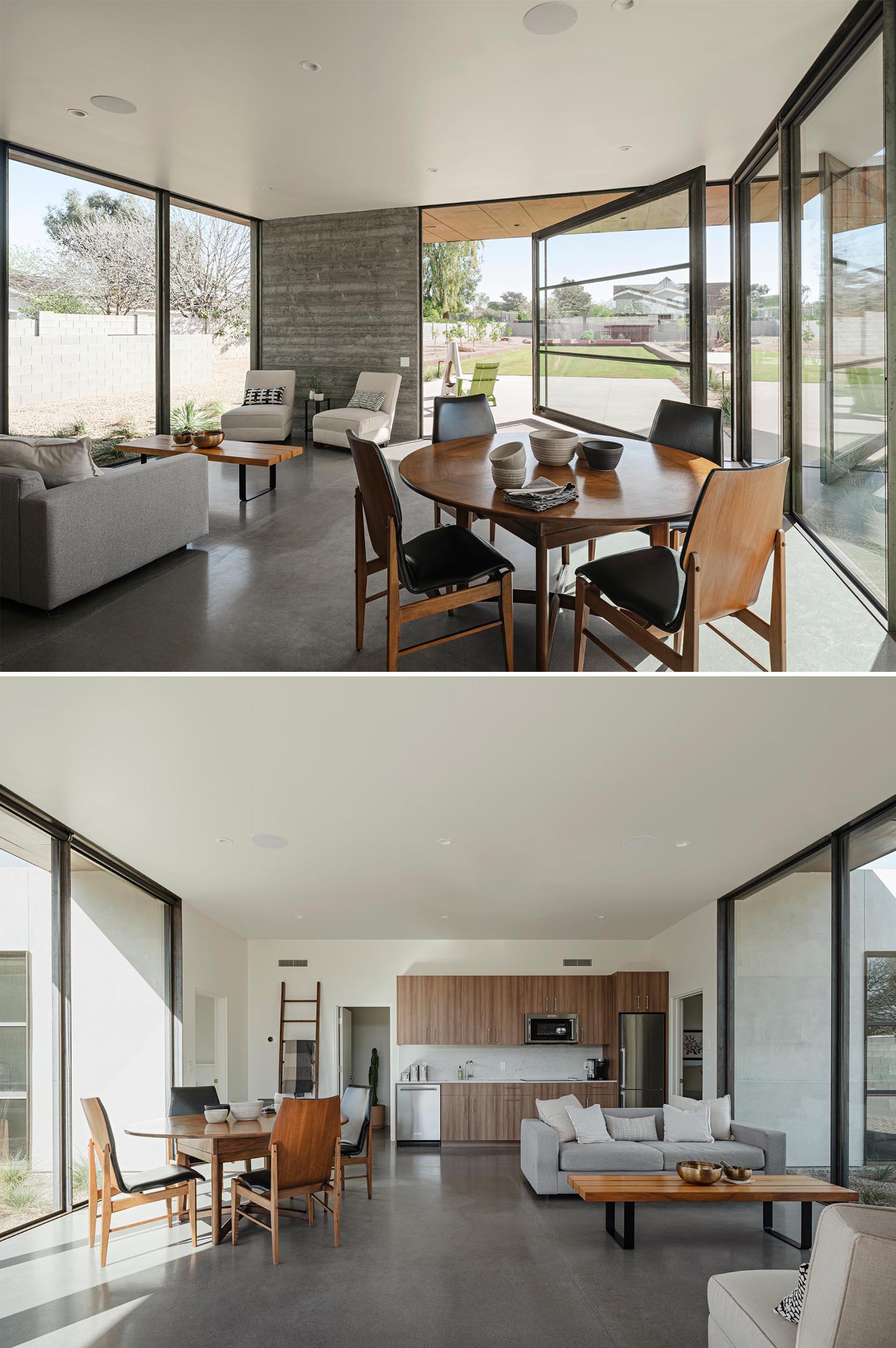 An open plan living room, dining area, and kitchen, with polished concrete floors and a large pivoting door.