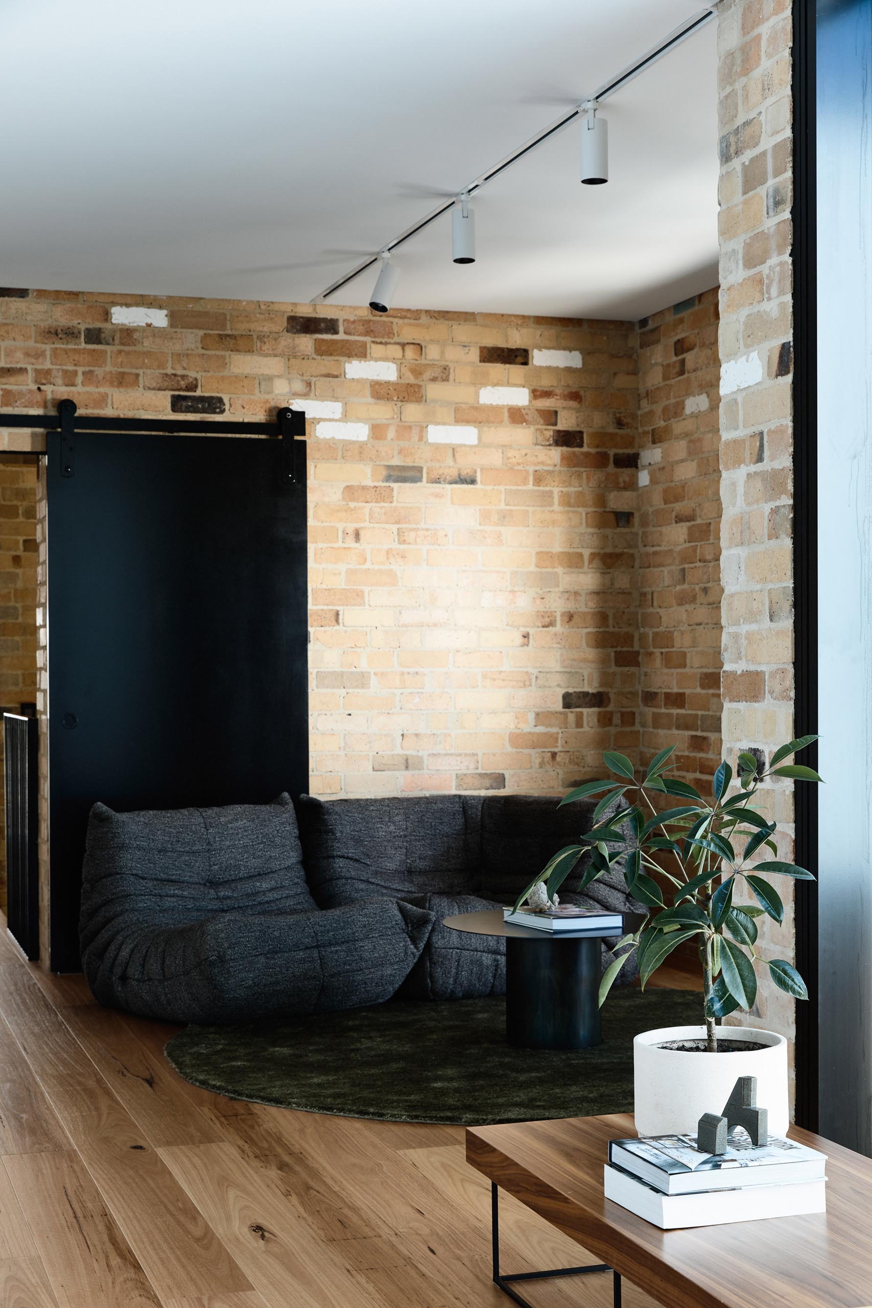 A sitting room furnished with a black sofa.