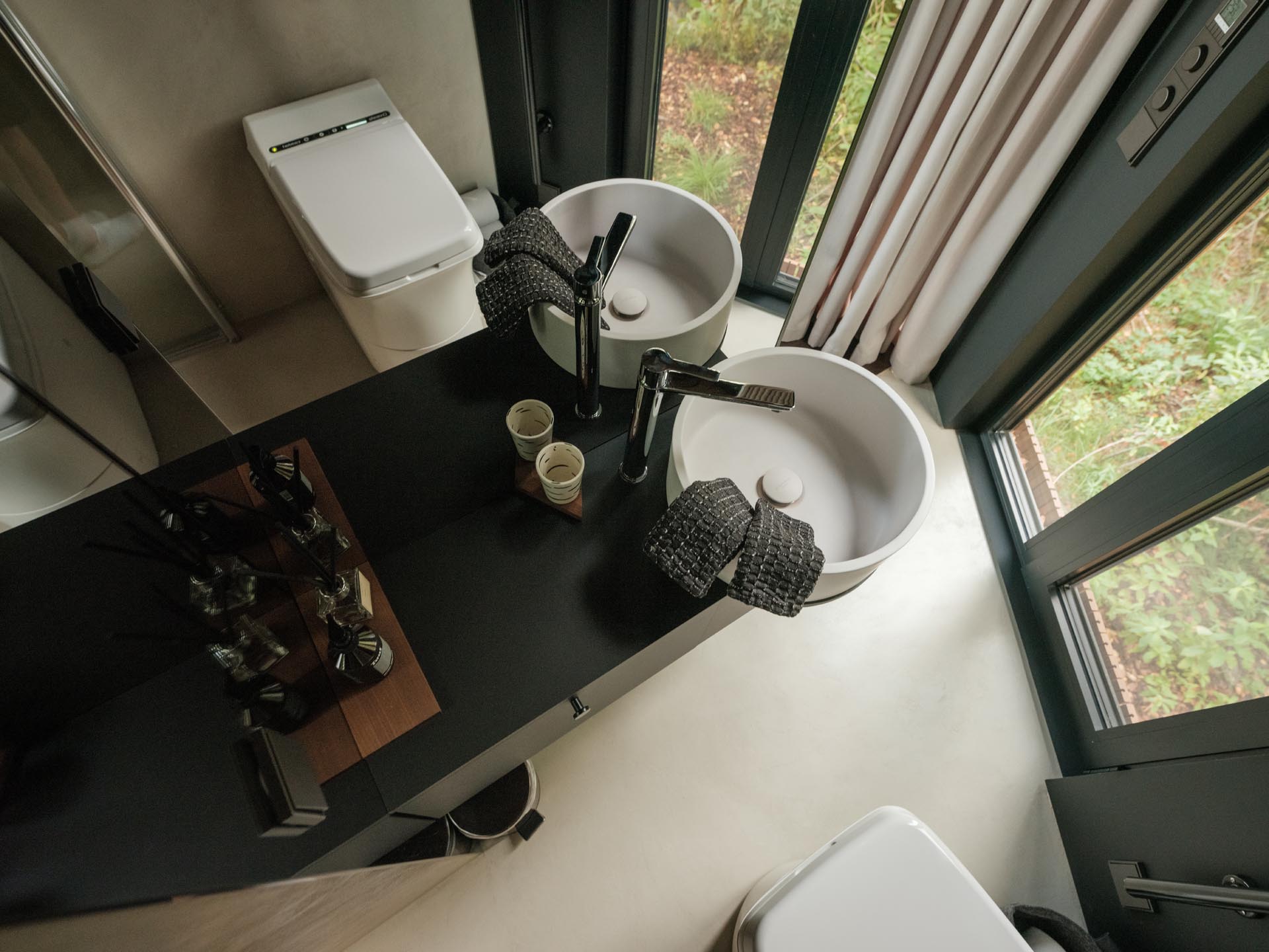 A small bathroom that includes floor-to-ceiling mirrors and an incineration toilet.