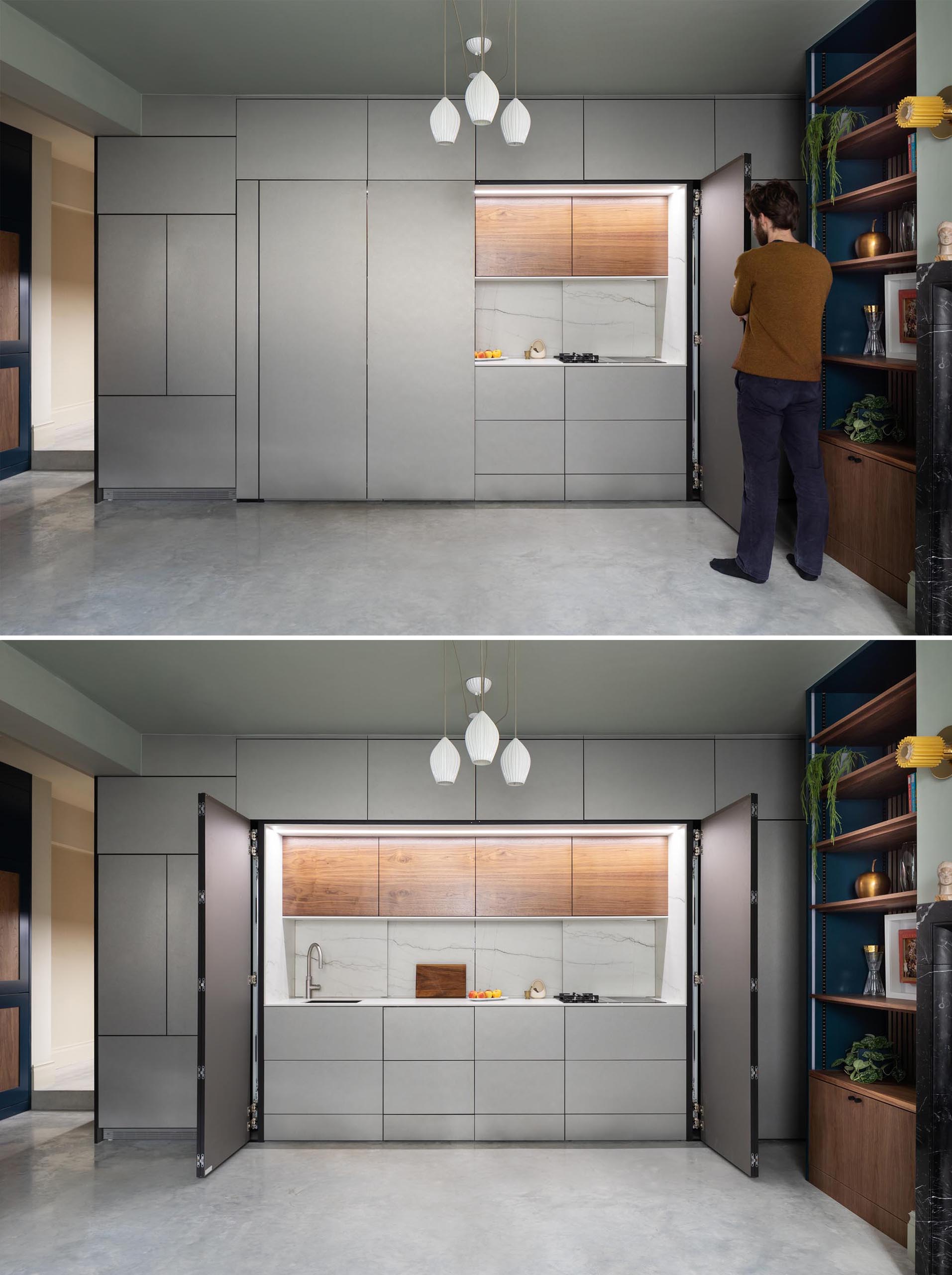 This kitchen, which can hidden away when not in use, is enclosed in muted metallic gray cabinets. The main section of the kitchen is accessed via a pair of folding doors.