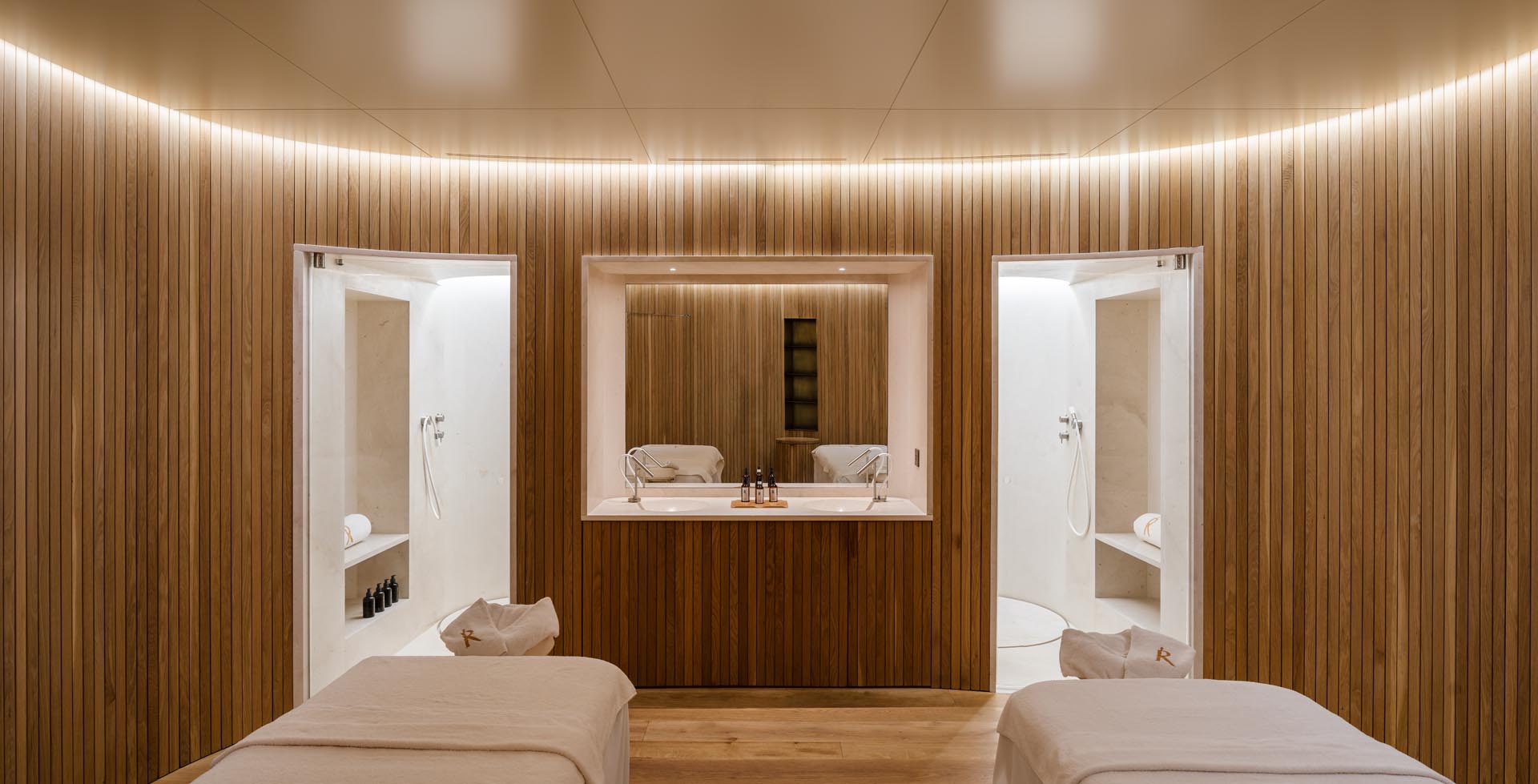 Modern massage rooms with wood slat curved walls and hidden lighting.