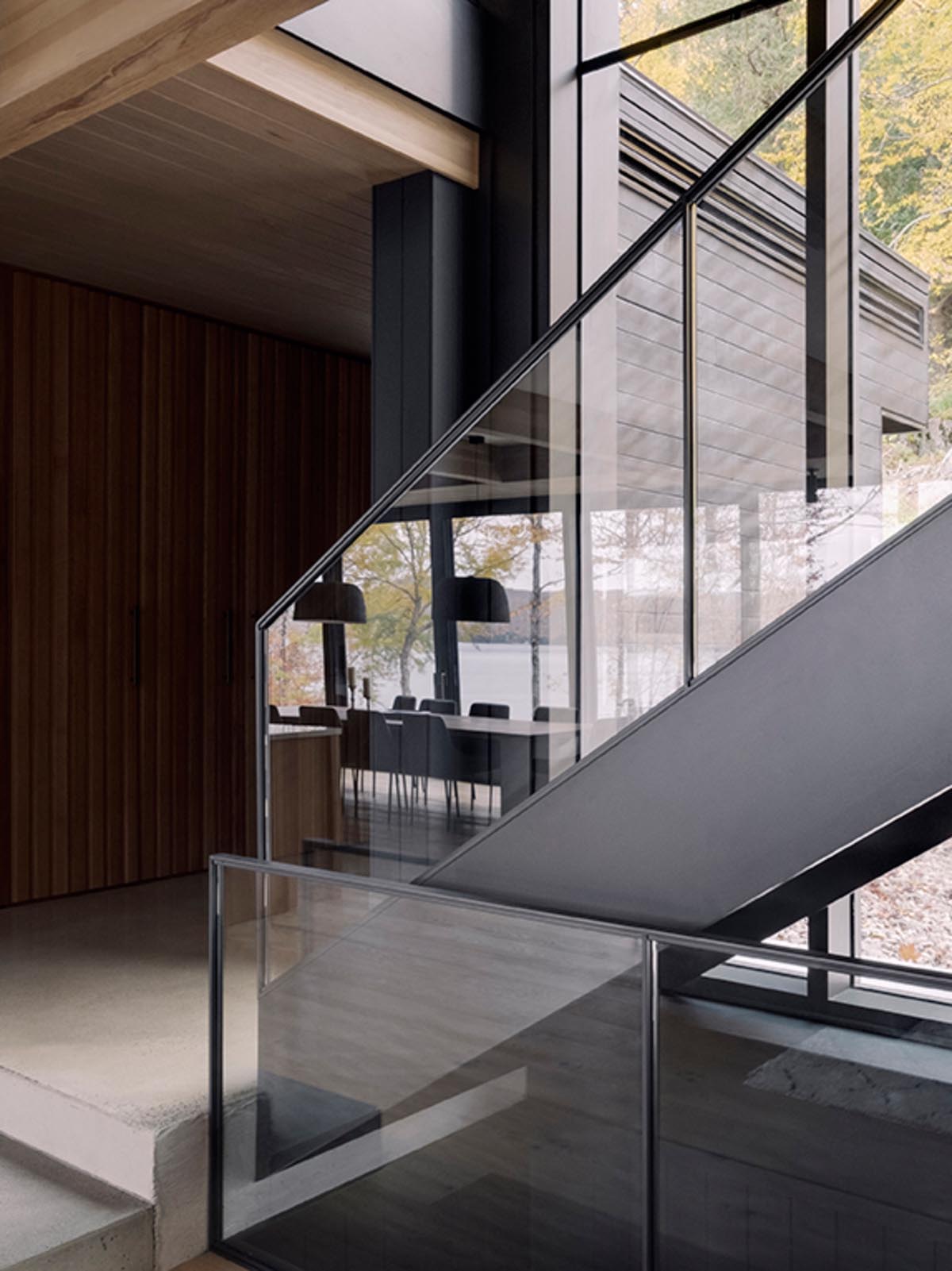 Steel and glass stairs connect the various levels of the home, with the adjacent windows providing ample natural light.