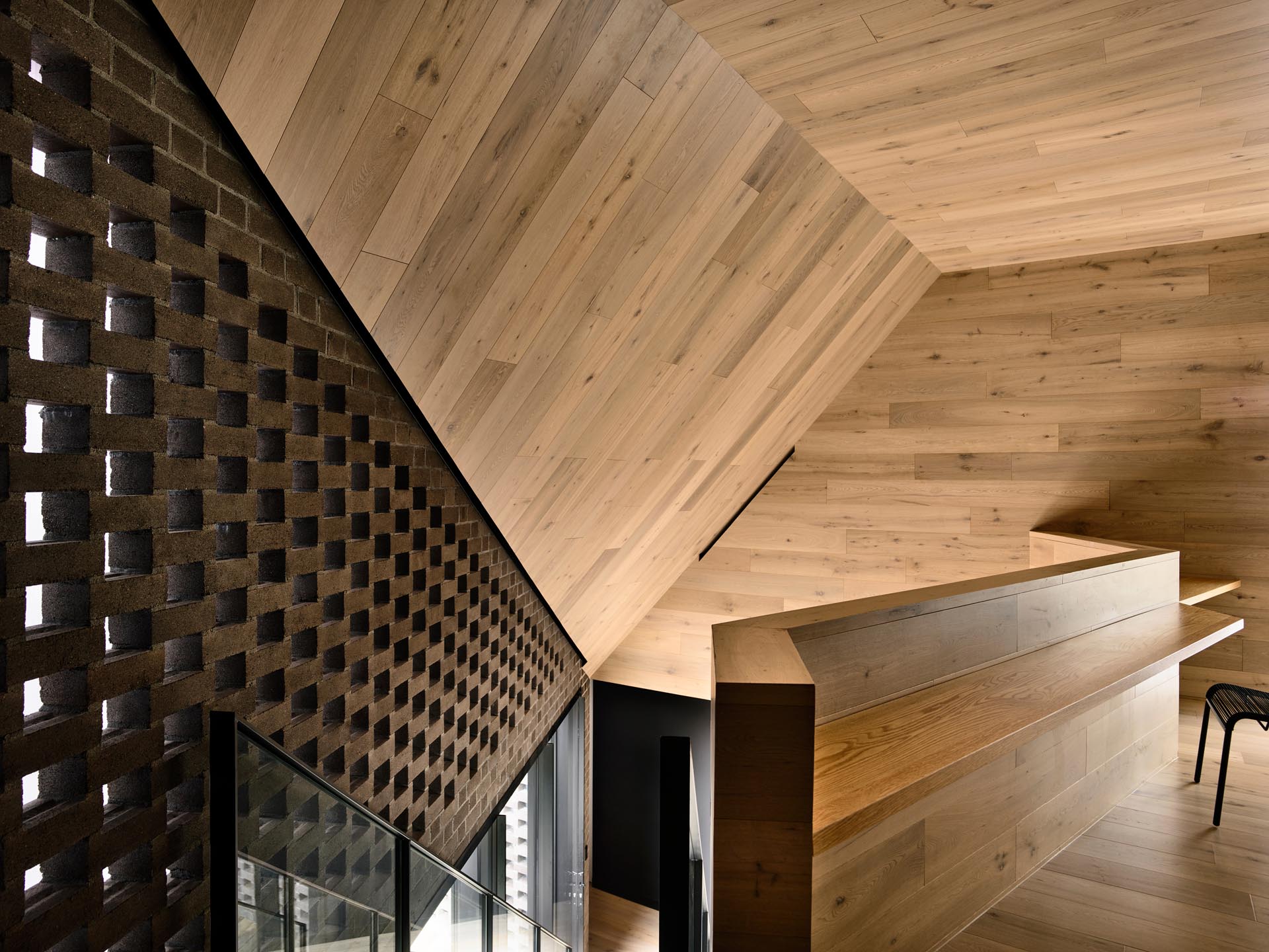 At the top of these modern stairs, there's a custom-designed study nook which has a clear view of the origami-inspired angled ceiling.