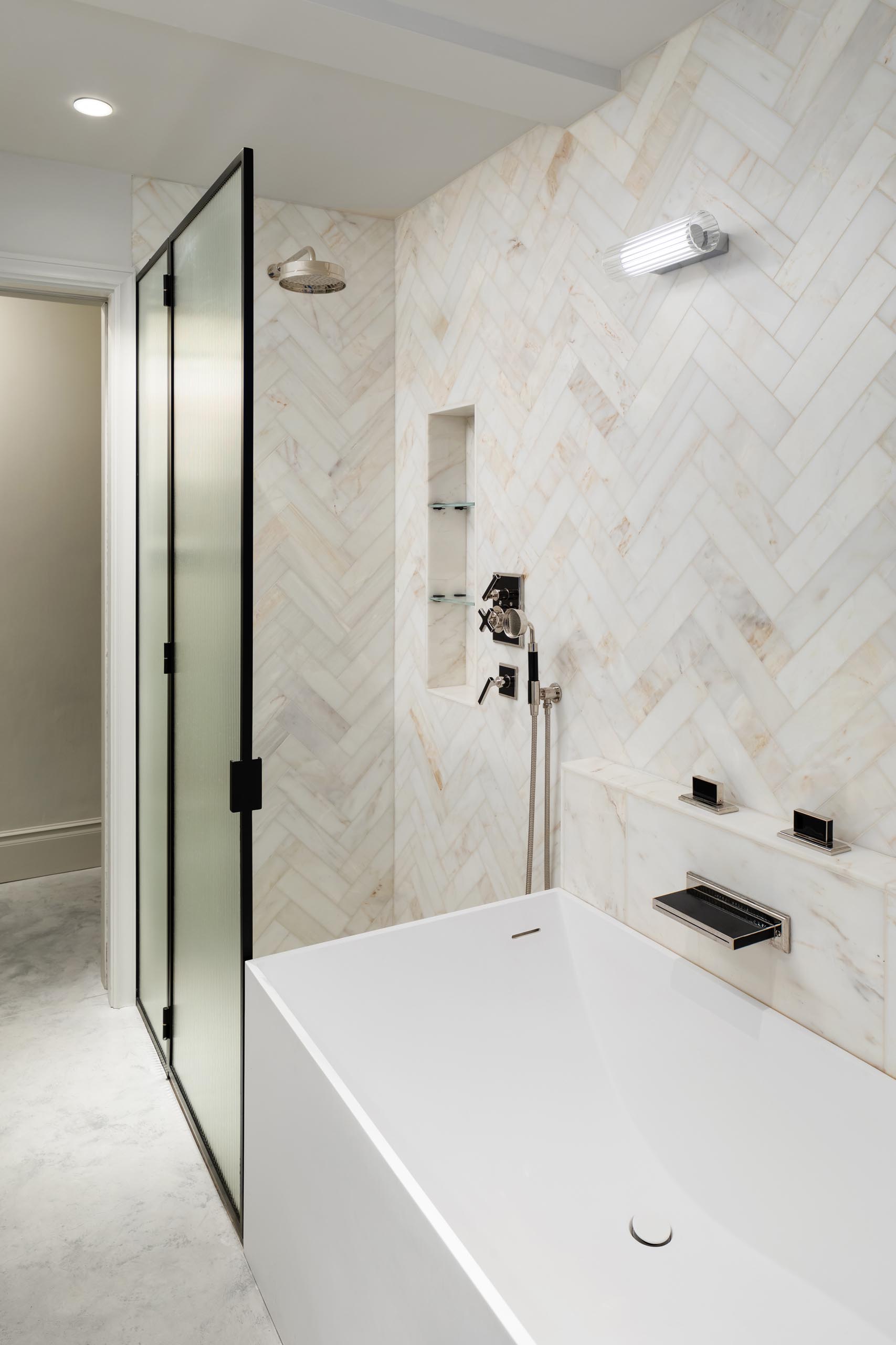 A modern bathroom with a walk-in shower that meets the bathtub.