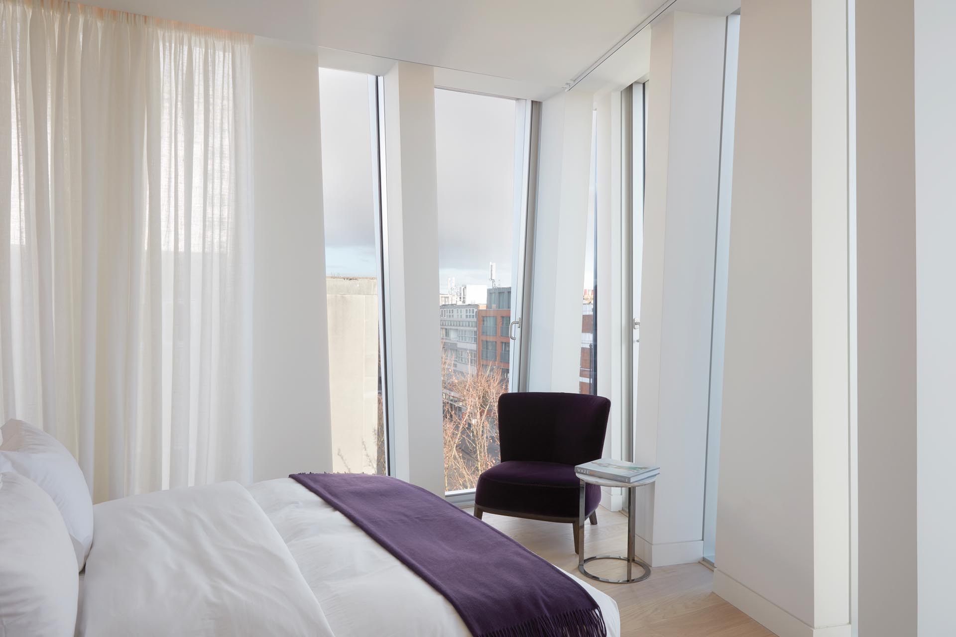 A modern bedroom with unique triangular window shapes.