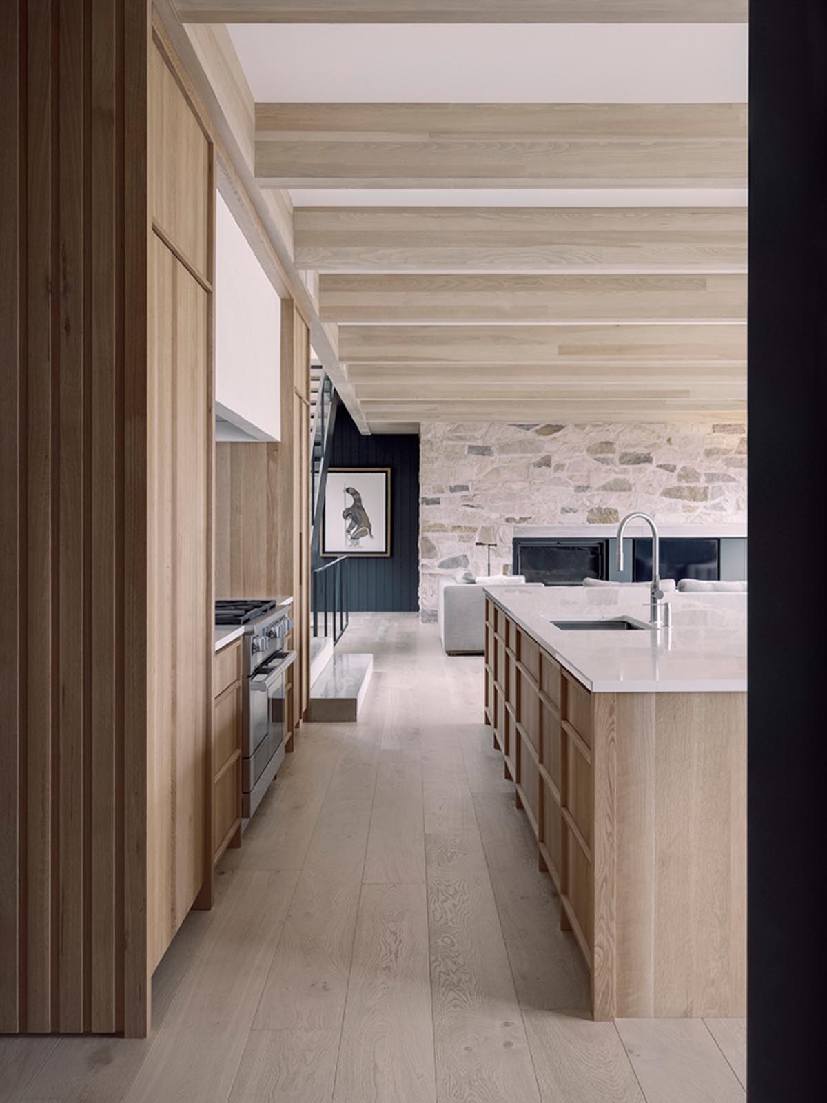 A modern kitchen with hardware-free wood cabinets and a large island that increases the available countertop space.