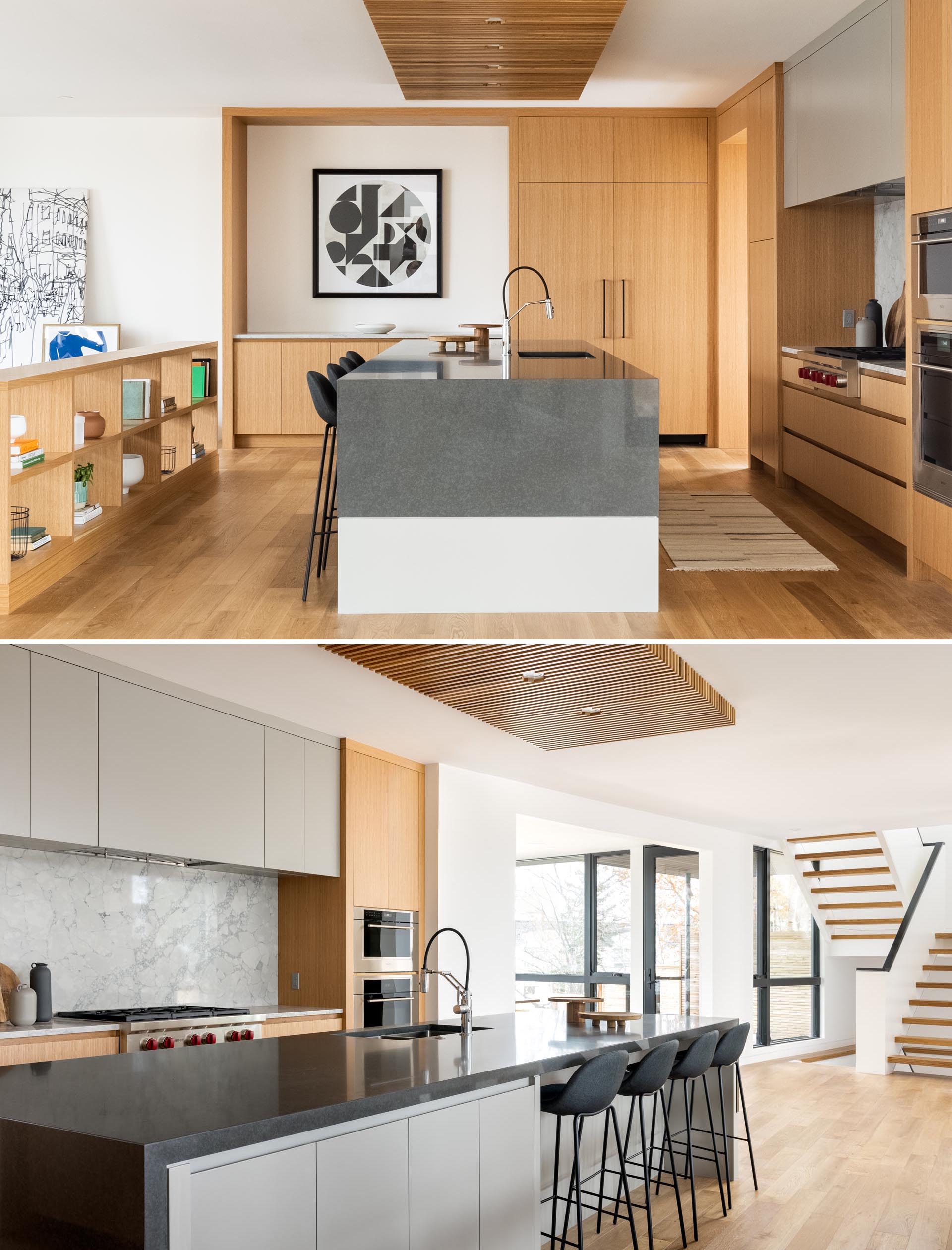 This modern kitchen includes a large island with a wood ceiling accent and light wood cabinets.