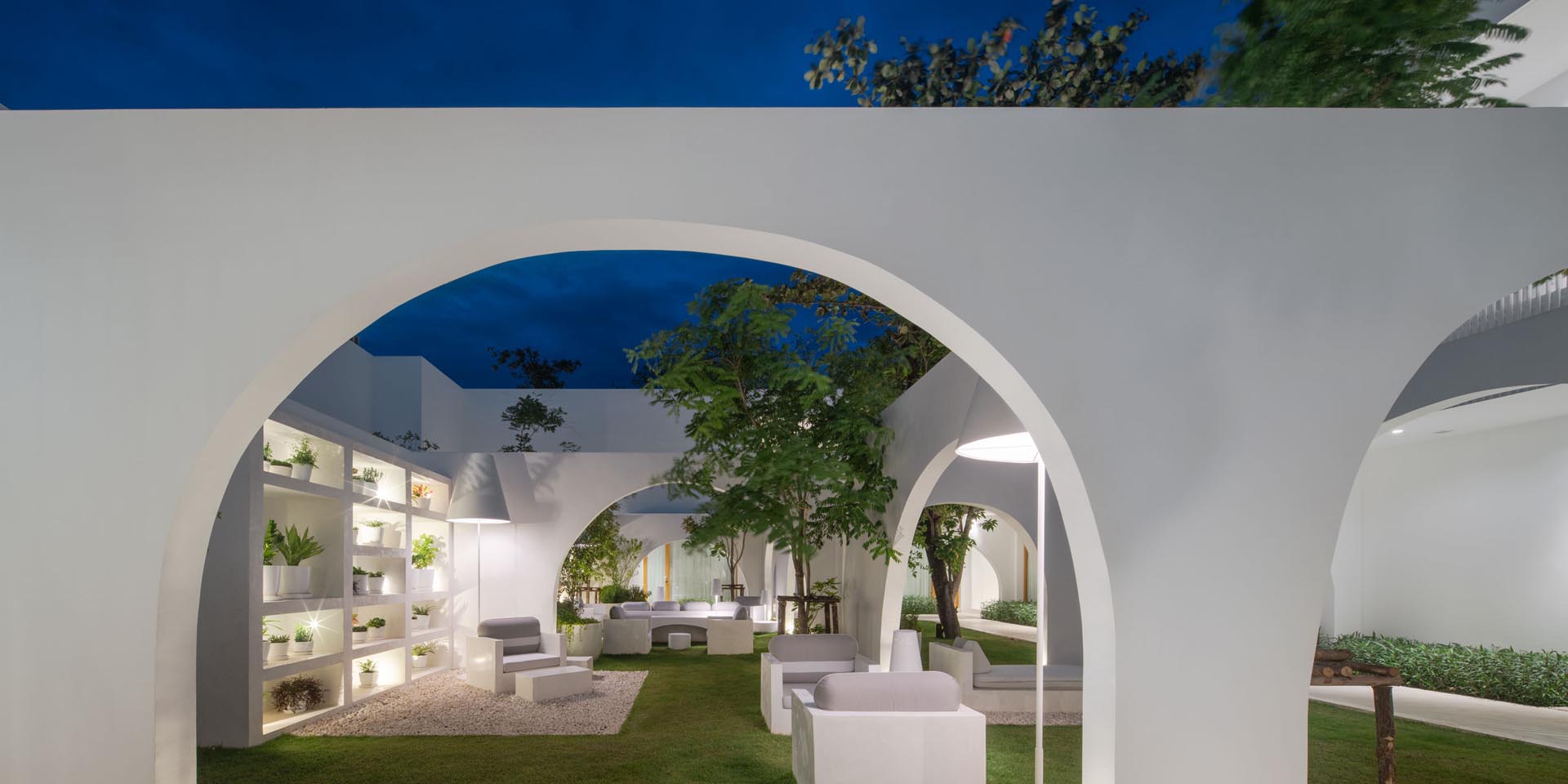 An outdoor living room with a shelving unit designed to house plants.