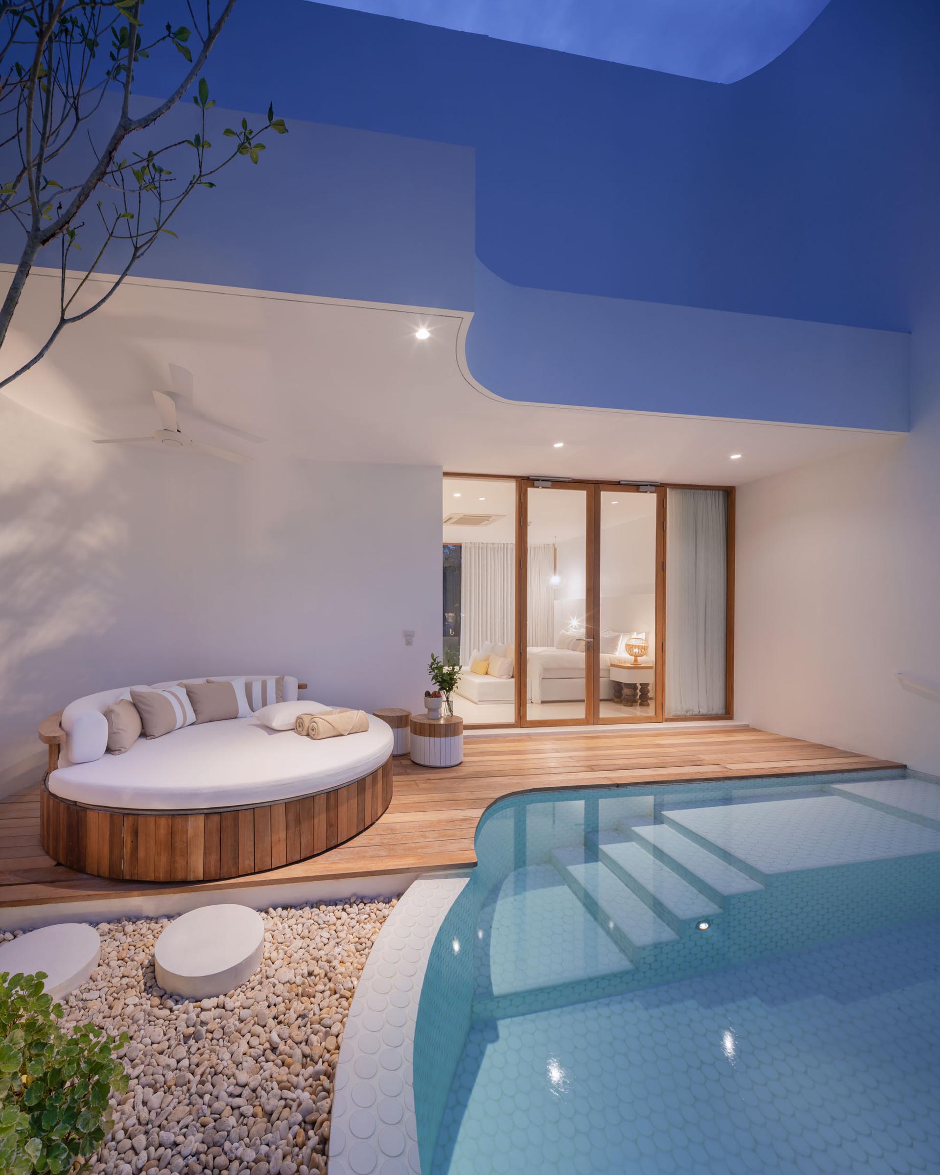 A hotel room with a small swimming pool and covered seating area.