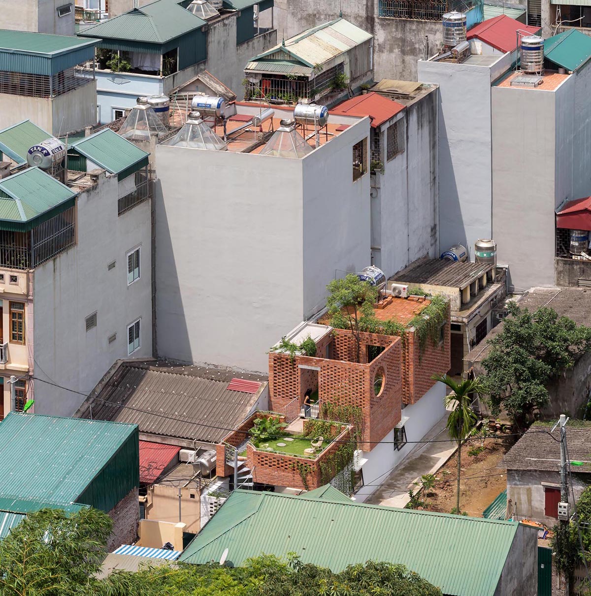 A contemporary home with rooftop courtyards surrounded by brick.