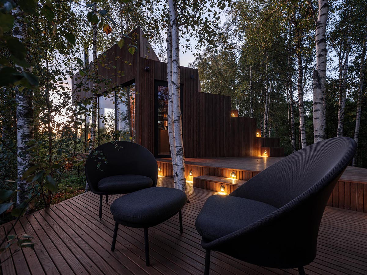 At night, exterior lighting creates a cozy atmosphere for this cabin's deck.