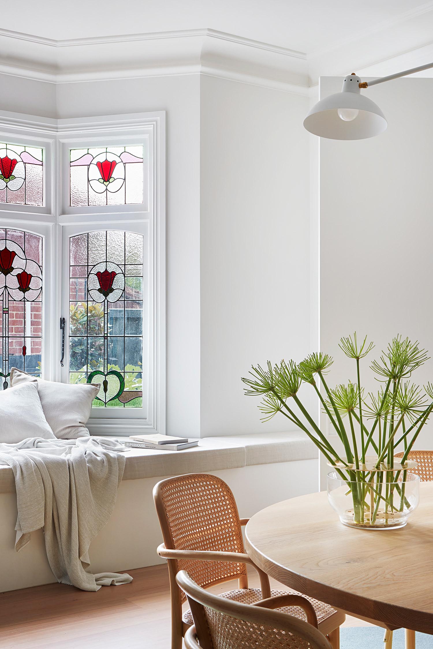 A remodeled dining room with a bench by the bay windows.