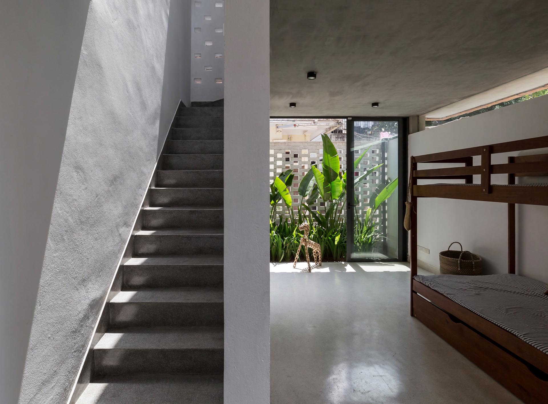 A sliding glass door opens the bedroom to green space.