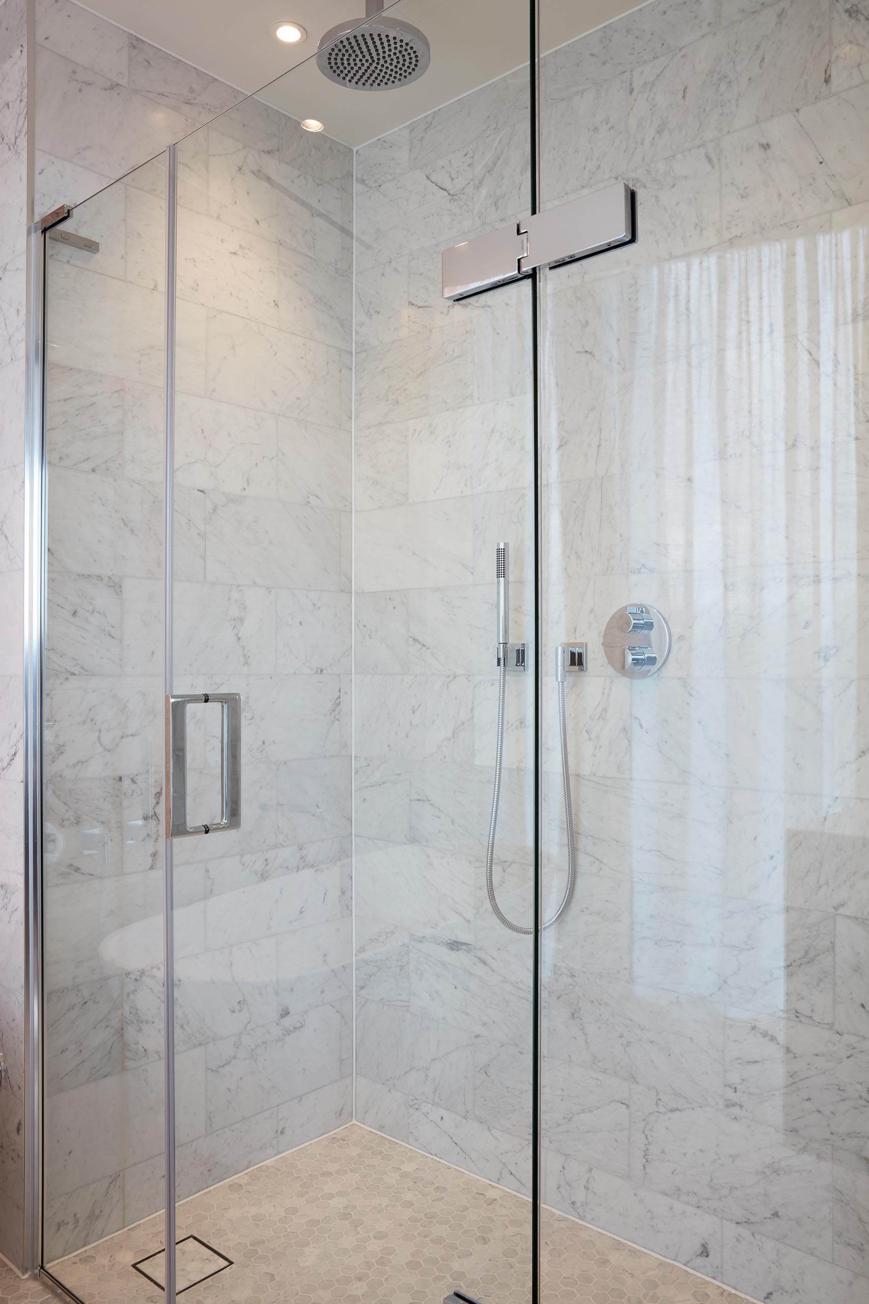 A modern walk-in shower with large gray tiles.