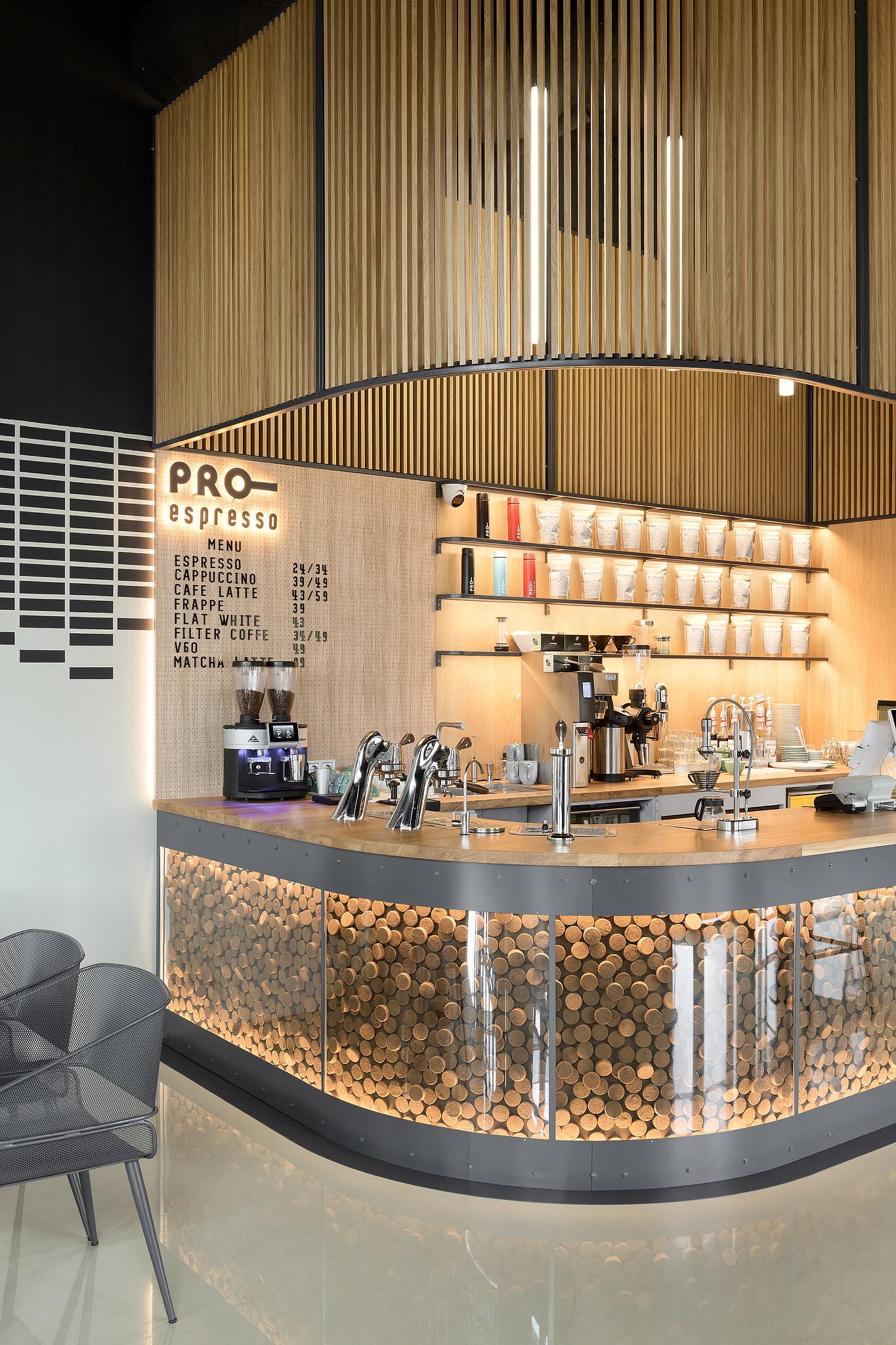 The bar counter of this modern coffee shop resembles the letter U and underneath the bar is a glass enclosed decorative accent that encloses 1300 tablets of coffee pomace.