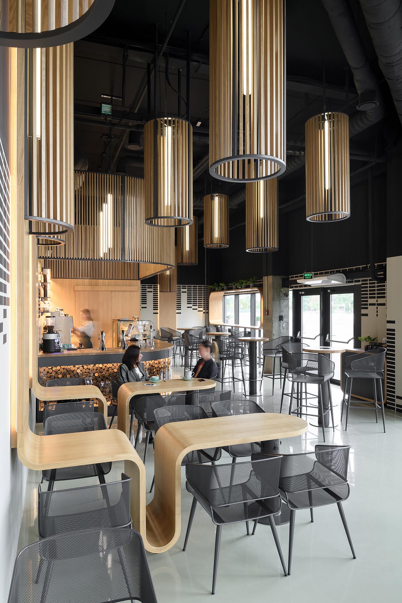 A modern coffee shop with custom designed oak tables that continue onto the wall.