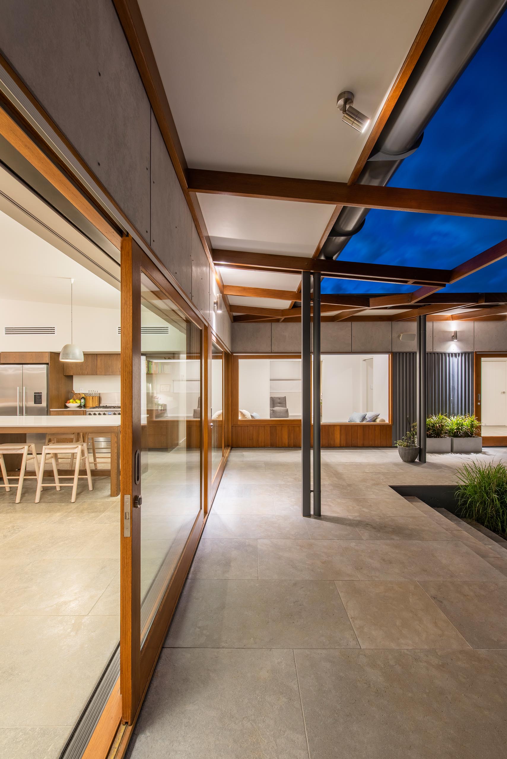 Wood-framed sliding glass doors open the living spaces to a wrap around patio.