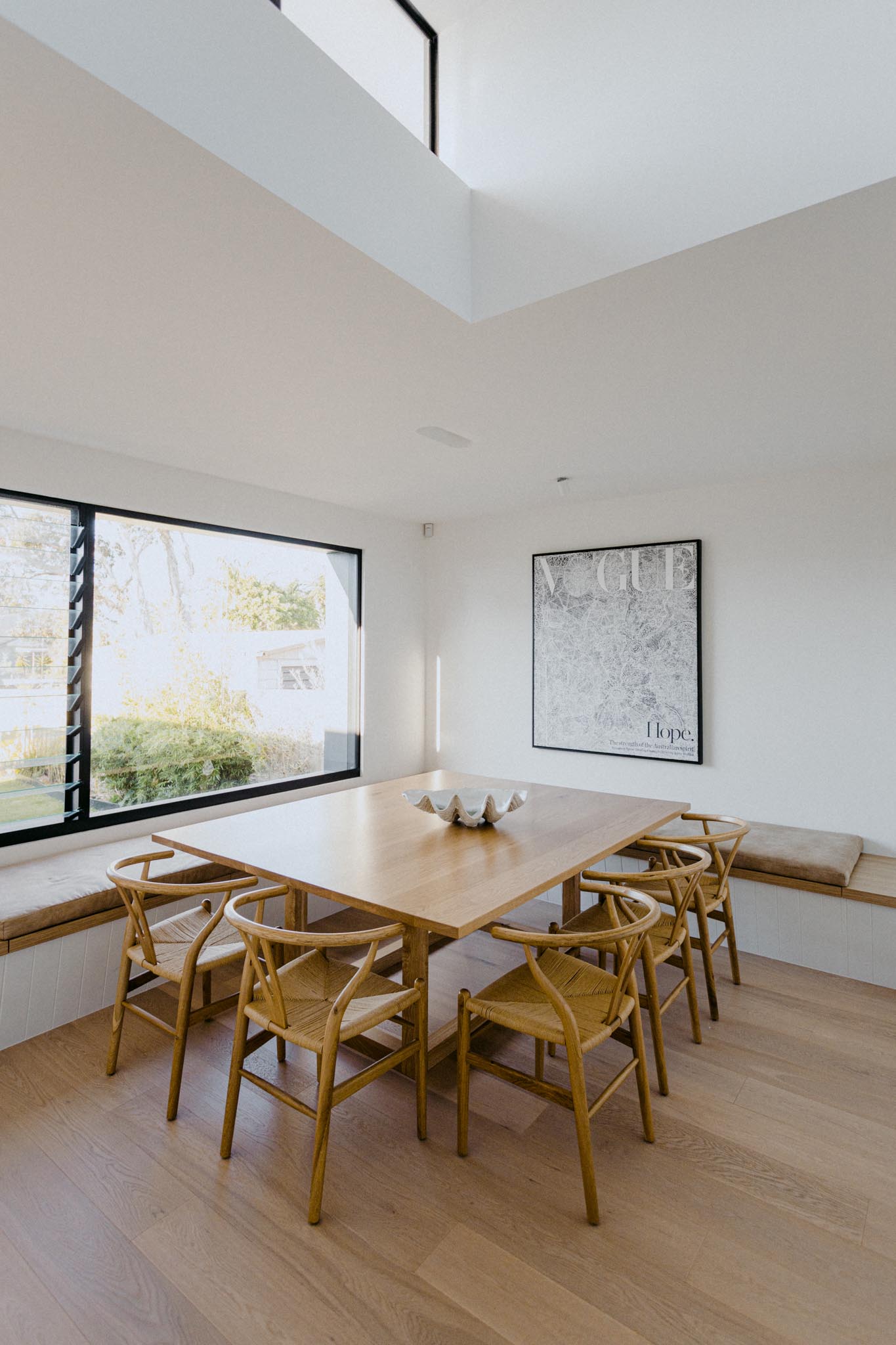 A modern dining room with benches that wrap around the corner of the room and provide plenty of seating when combined with the dining chairs.