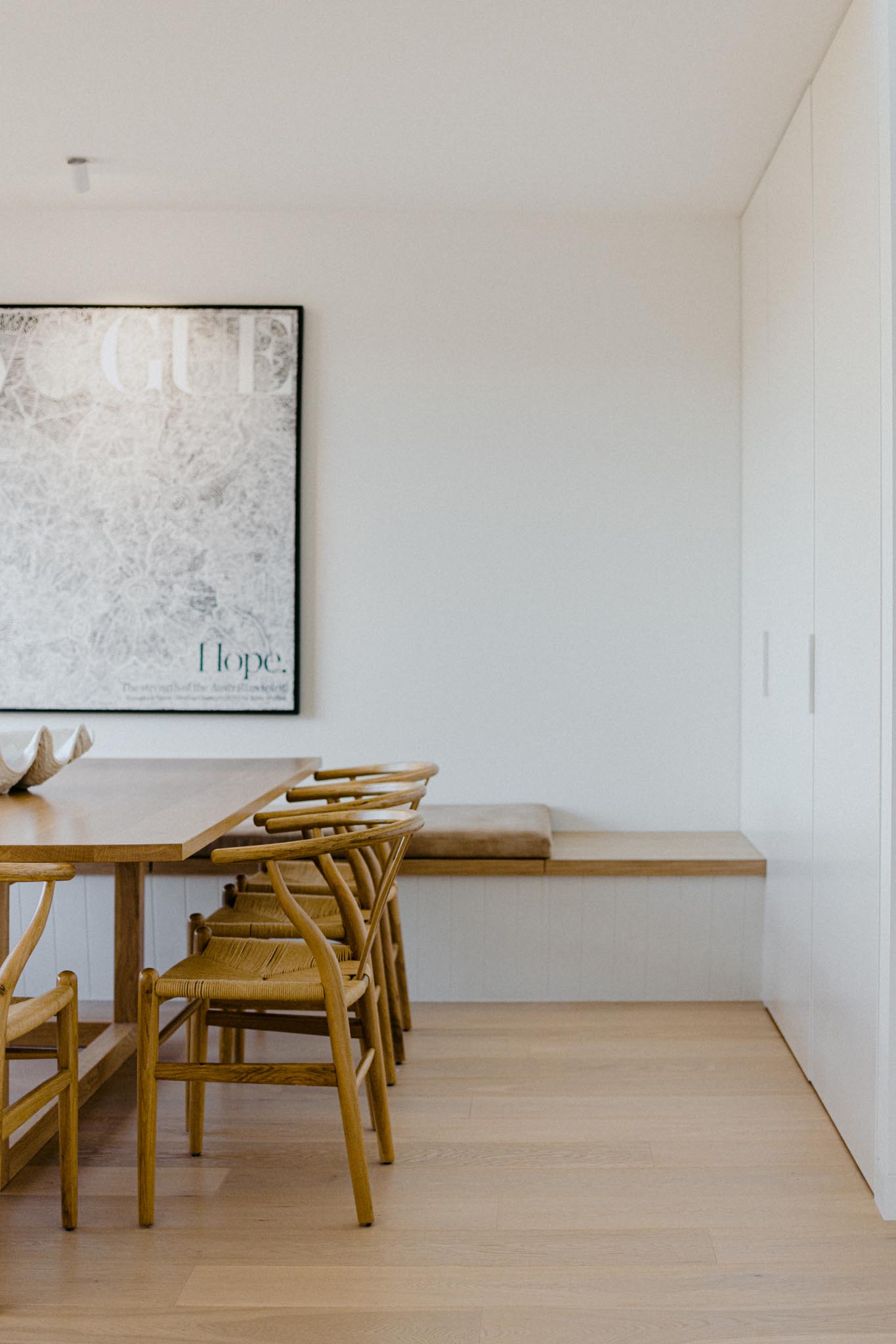 A modern dining room with benches that wrap around the corner of the room and provide plenty of seating when combined with the dining chairs.