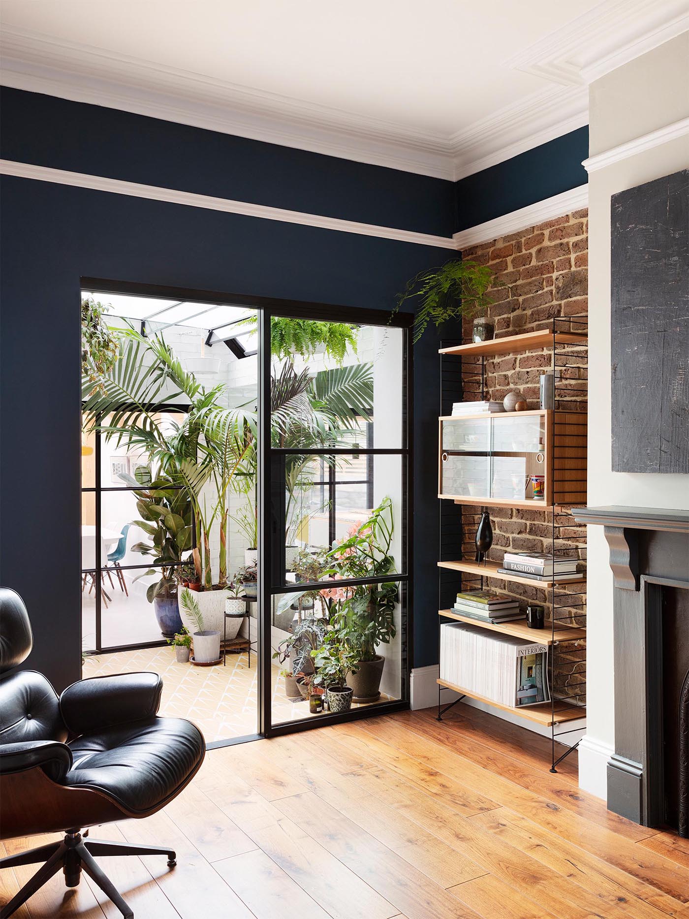 A contemporary home with an interior garden room with automated skylights, Ochre floor tiles, an irrigation system, and plenty of plants.