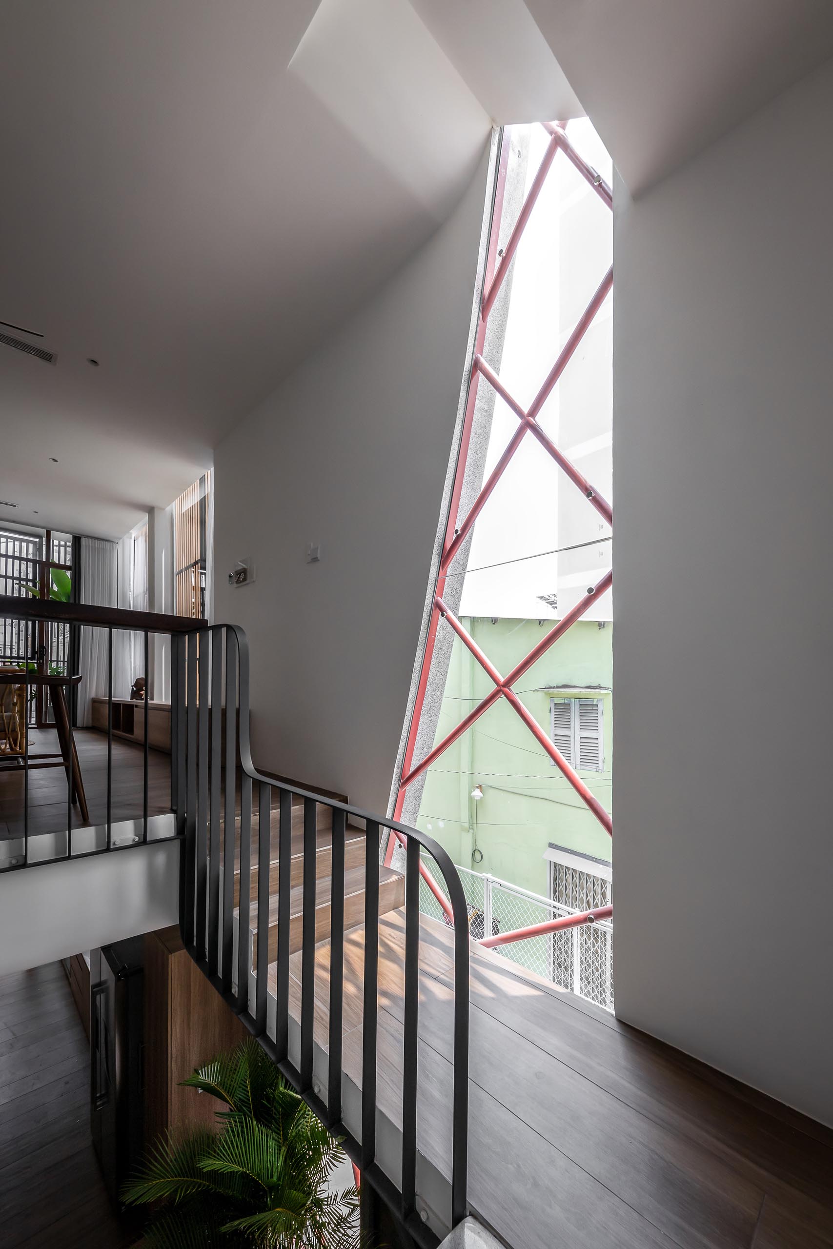 An irregular shaped window fills the entryway and staircase with natural light.