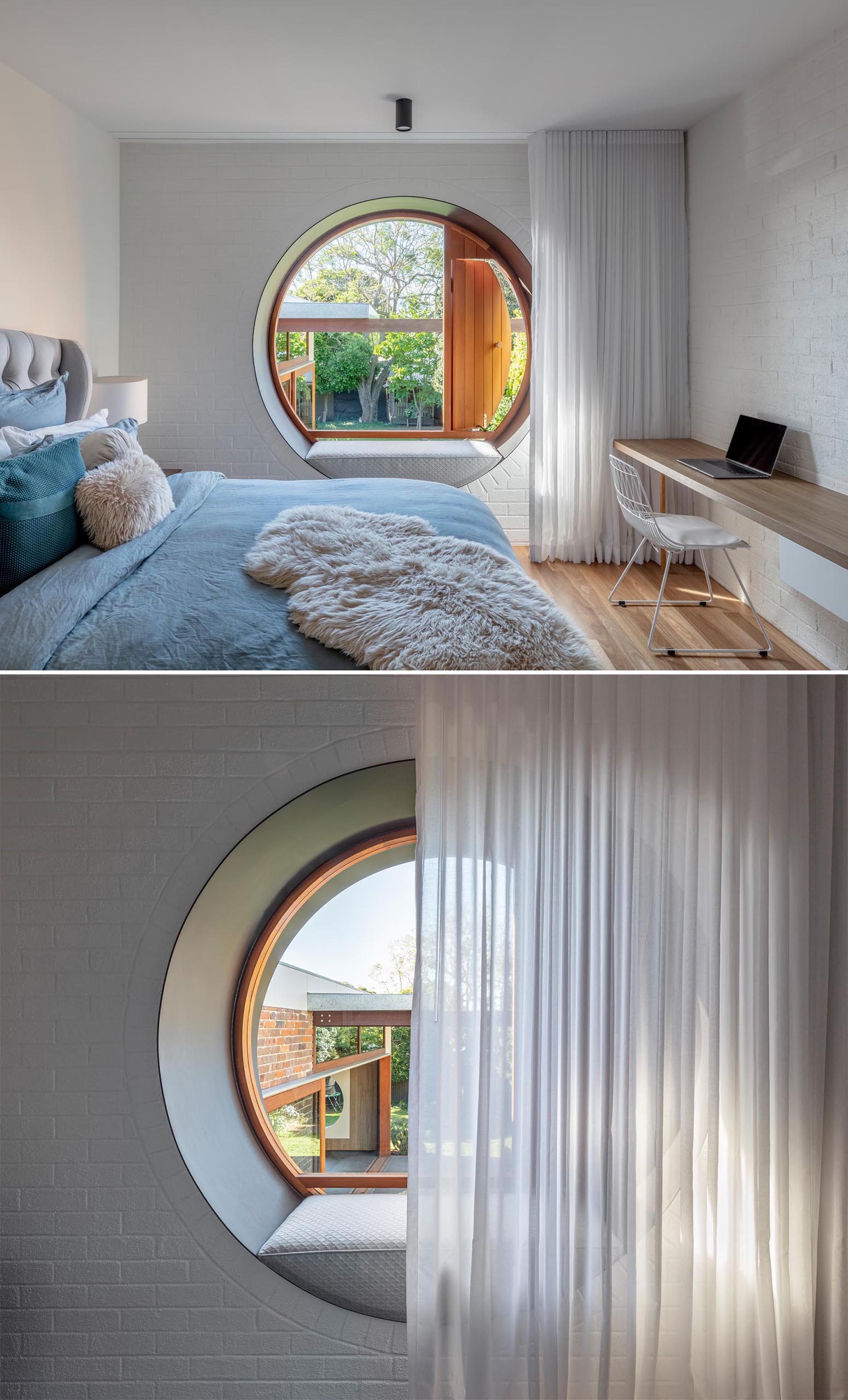 A modern bedroom with a desk and round window with a built-in bench.