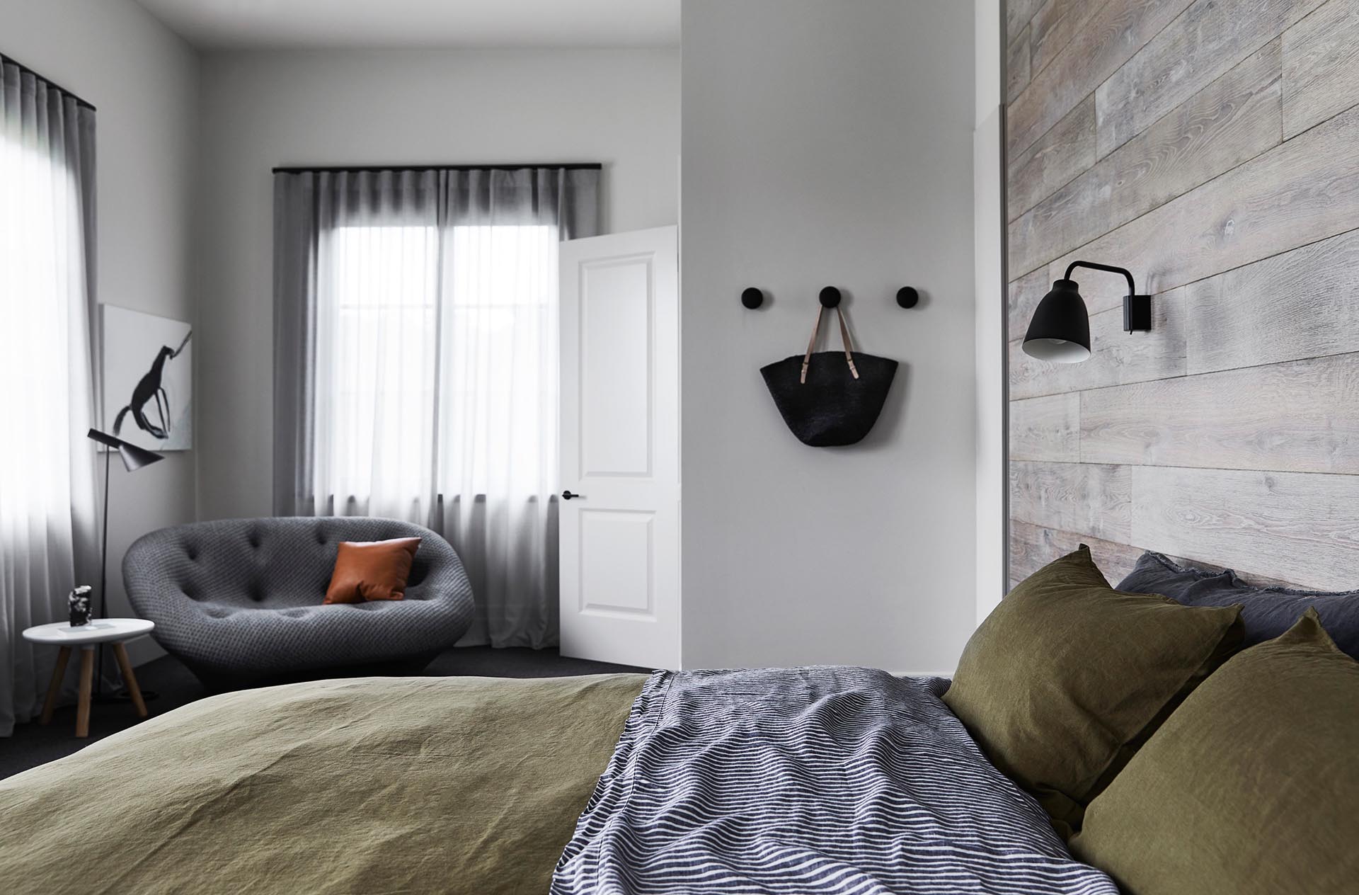 A modern farmhouse inspired bedroom with a French Oak wood accent wall.